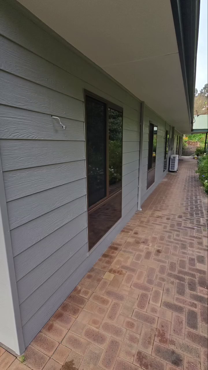 Exterior weatherboard cladding painted in modern charcoal grey along a residential walkway in Bickley.