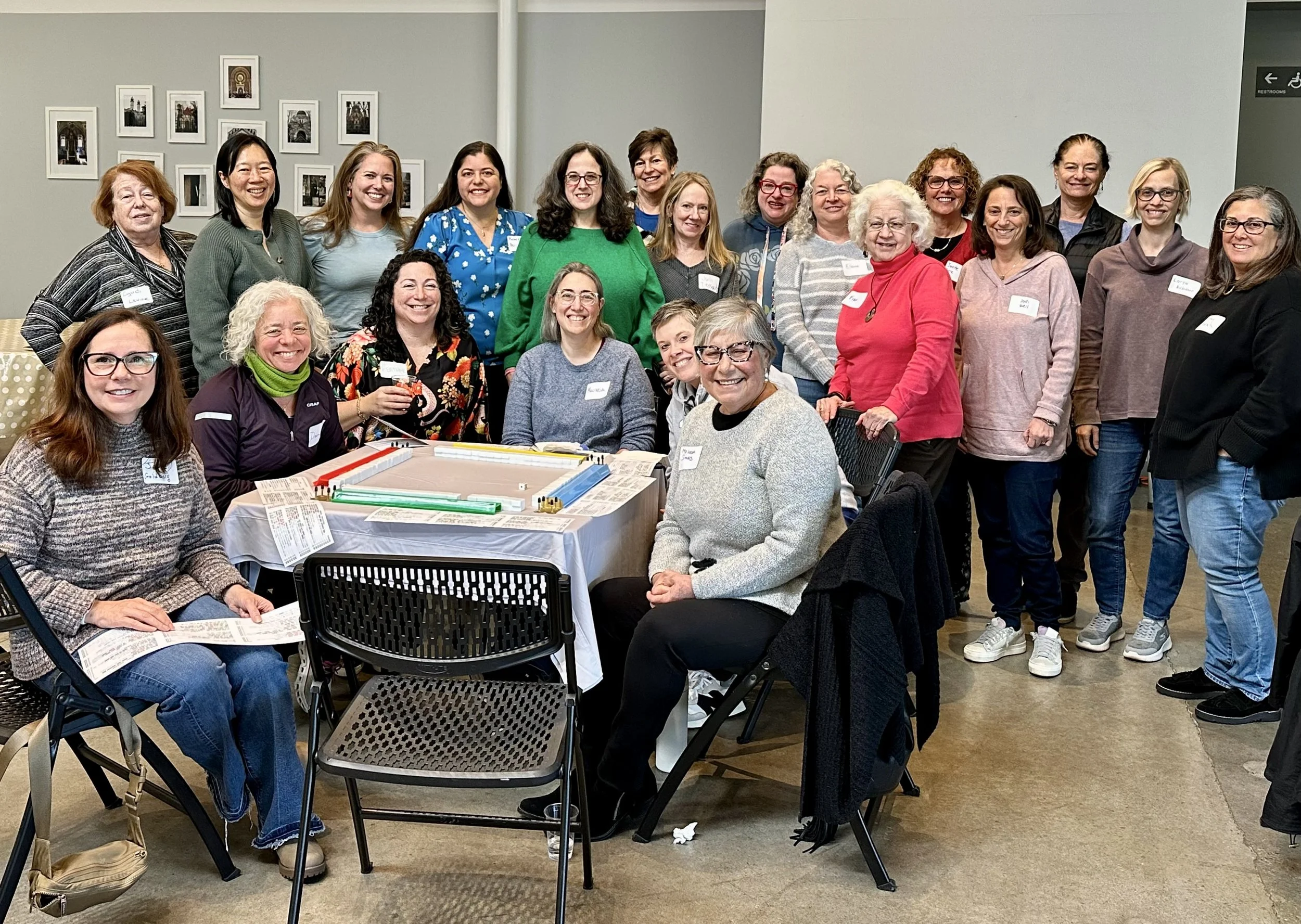 Group of women gathered around a table with a board game at a social event.