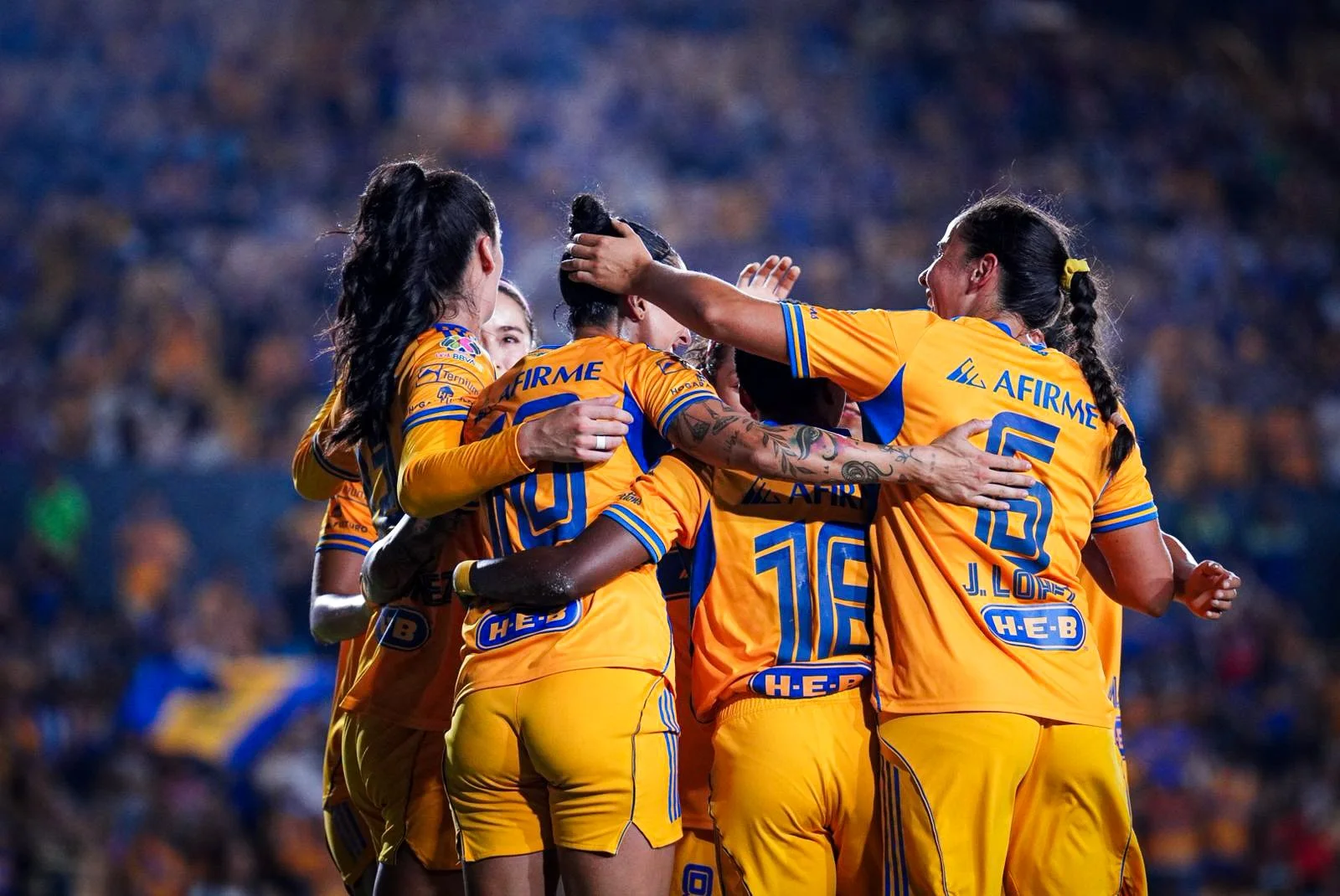 Jugadoras de Tigres femenil se abrazan festejando el gol de Hermoso