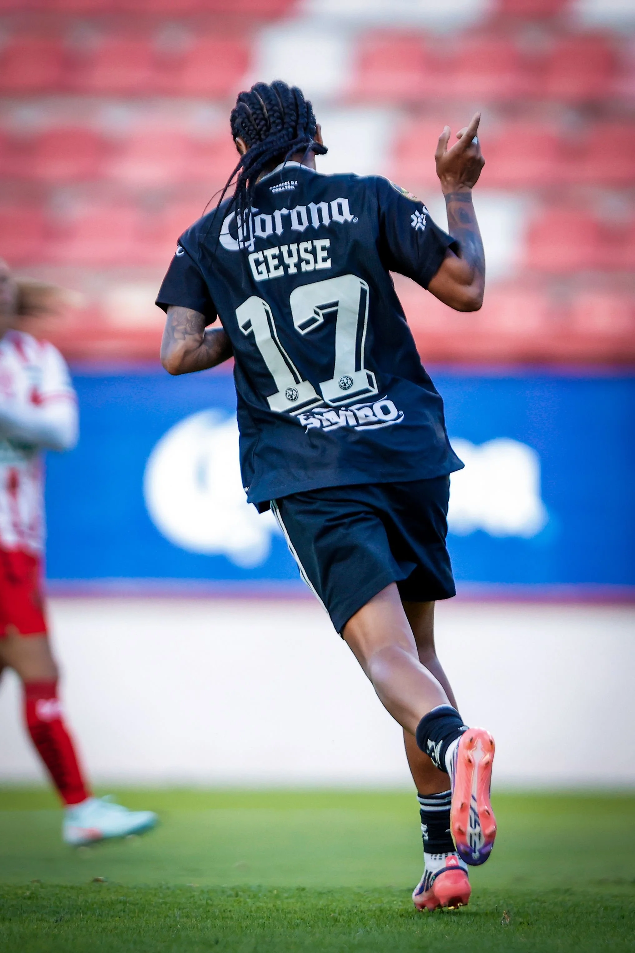 Geyse de espaldas señalando hacia un lado.