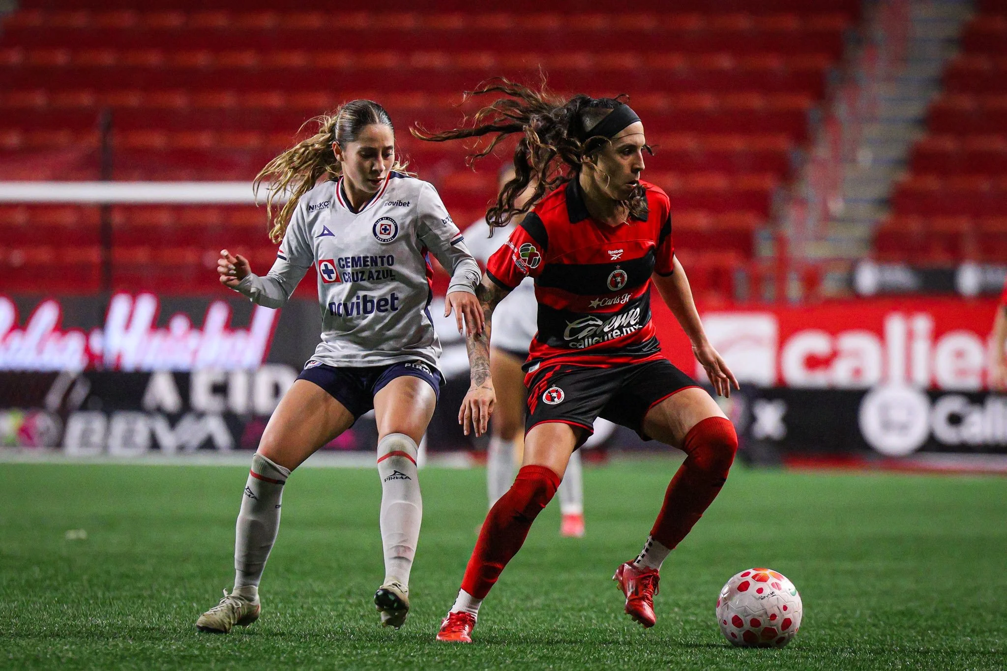 Fabi Ibarra conduce el balón ante la marca de Alejandra Lomelí.