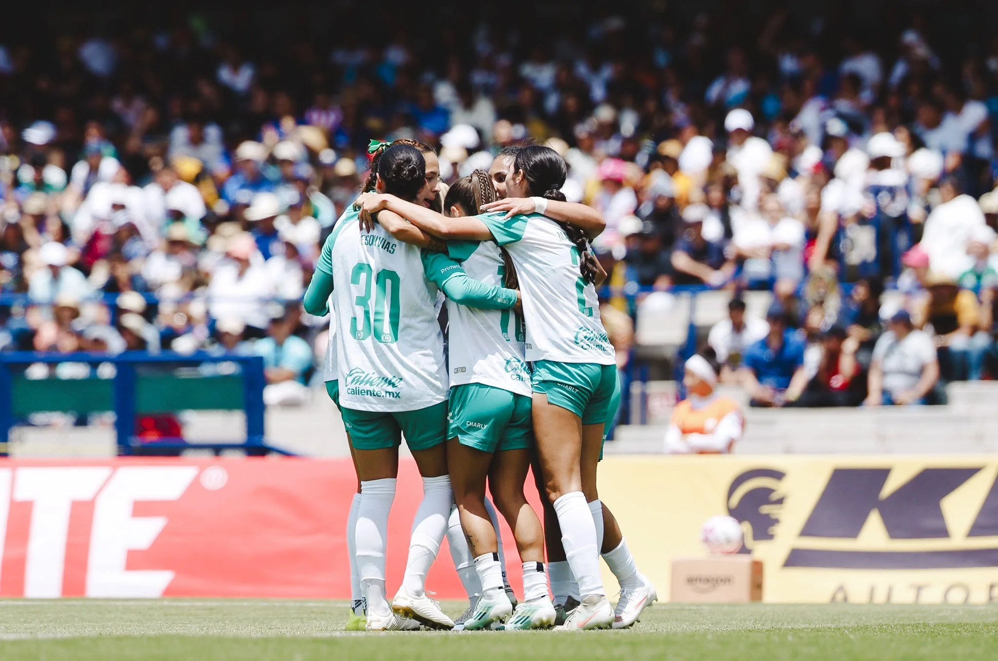 Jugadoras de León se abrazan festejando.