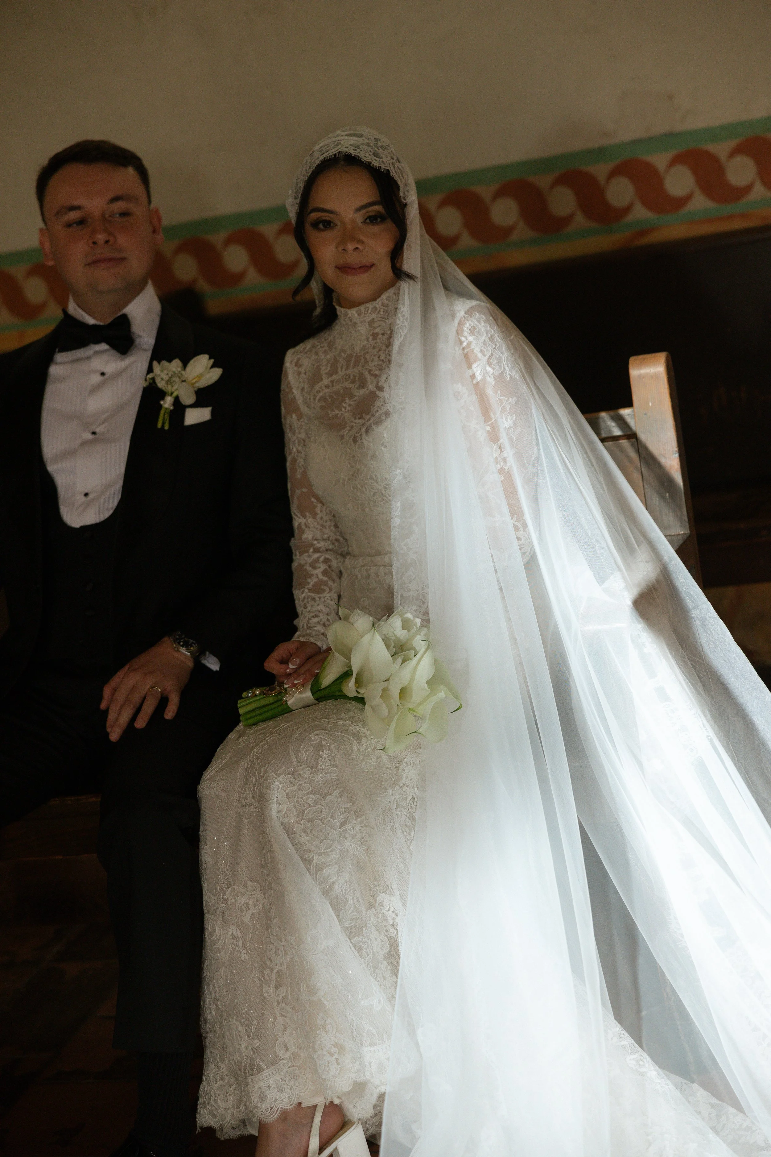bride and groom enjoying each others company on bench after wedding