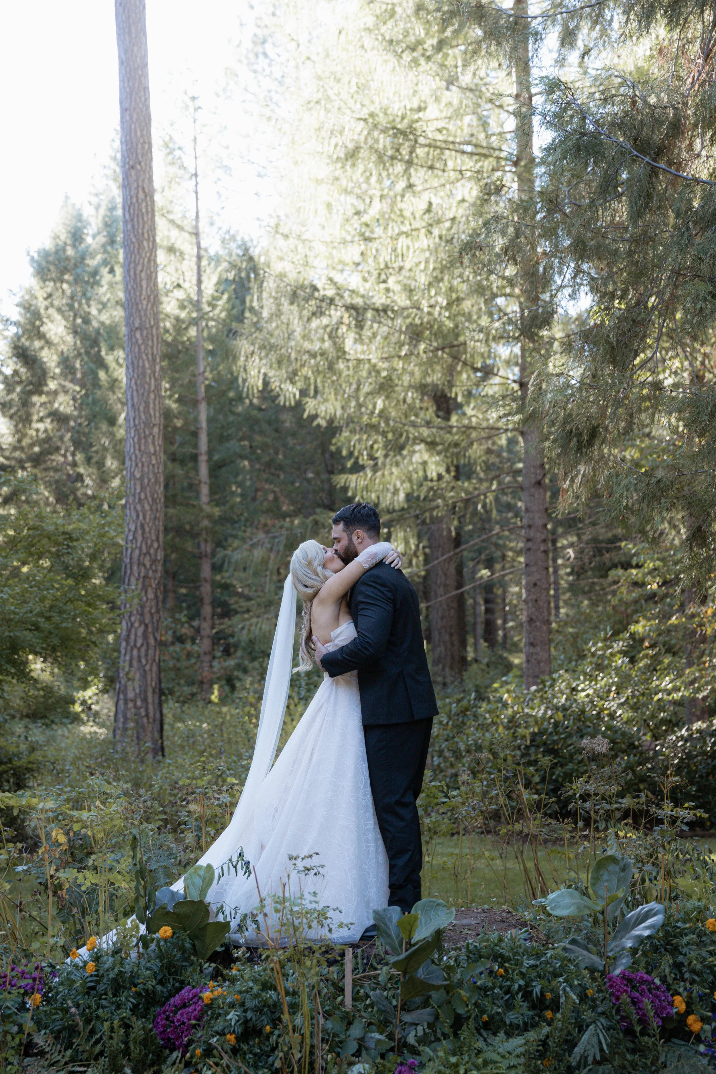 A bride and groom sharing their first kiss in their wedding ceremony at a California wedding venue