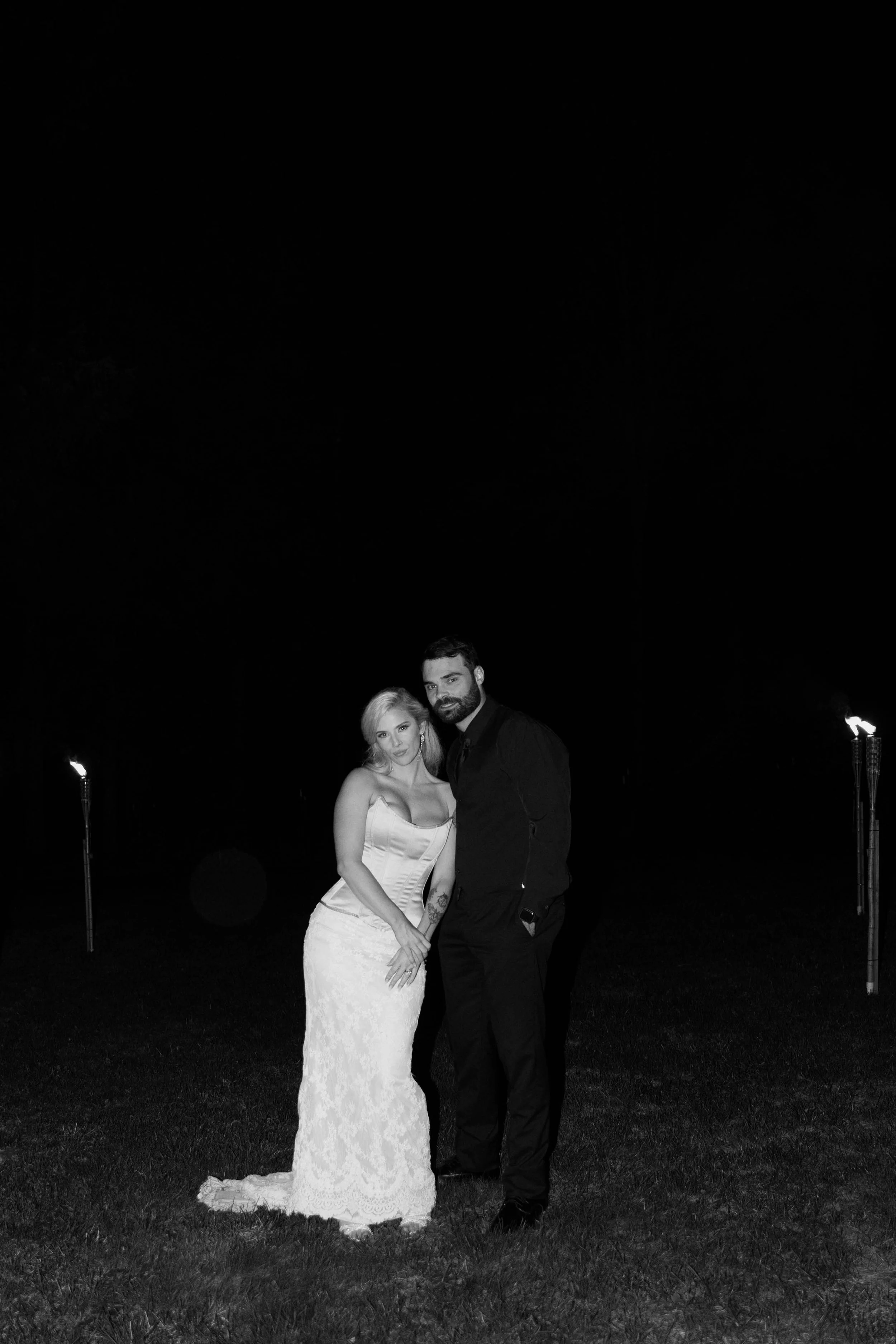 A black and white direct flash photo of a bride and groom