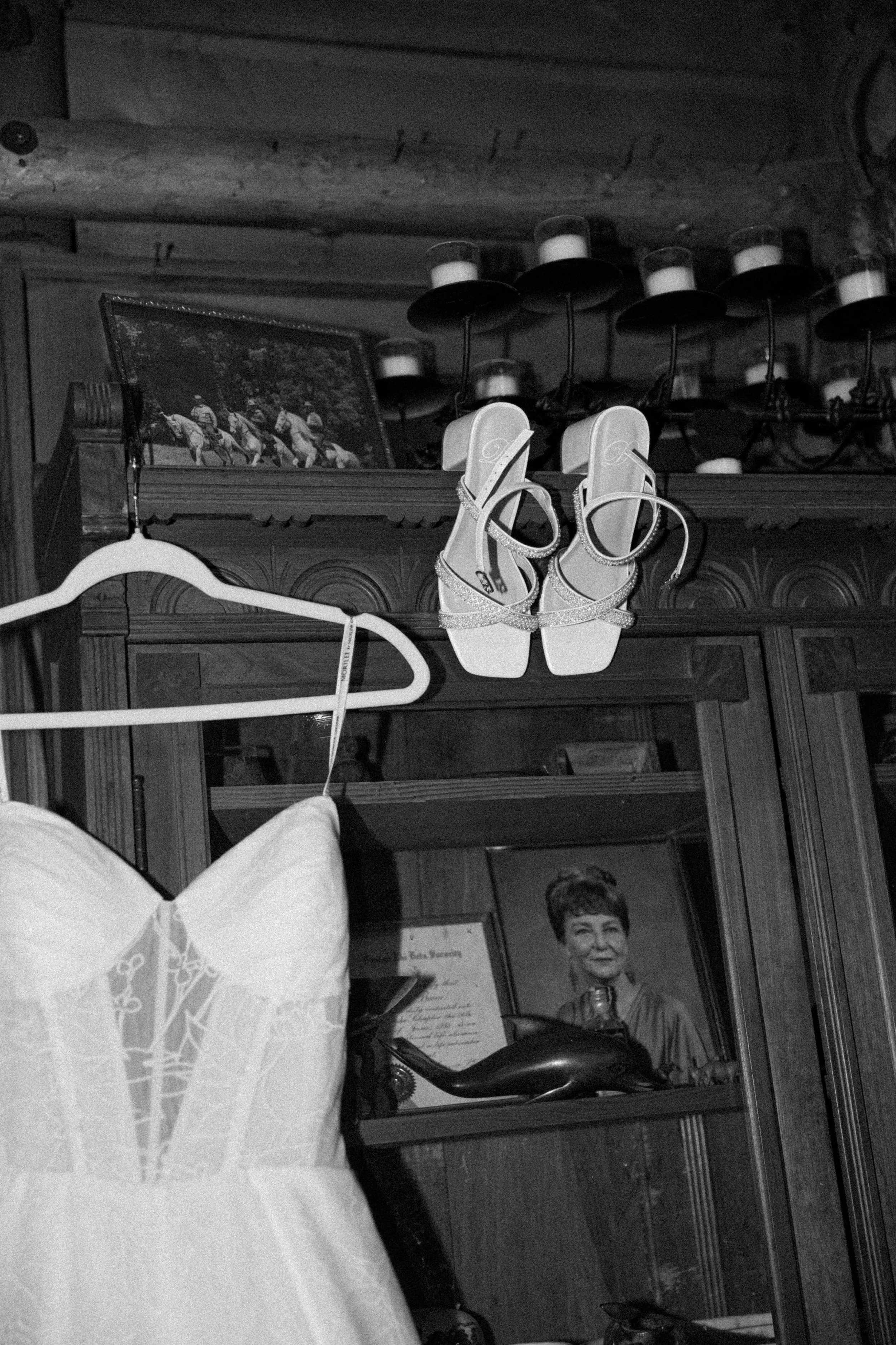 A bride's wedding dress and shoes hanging up in a California wedding venue