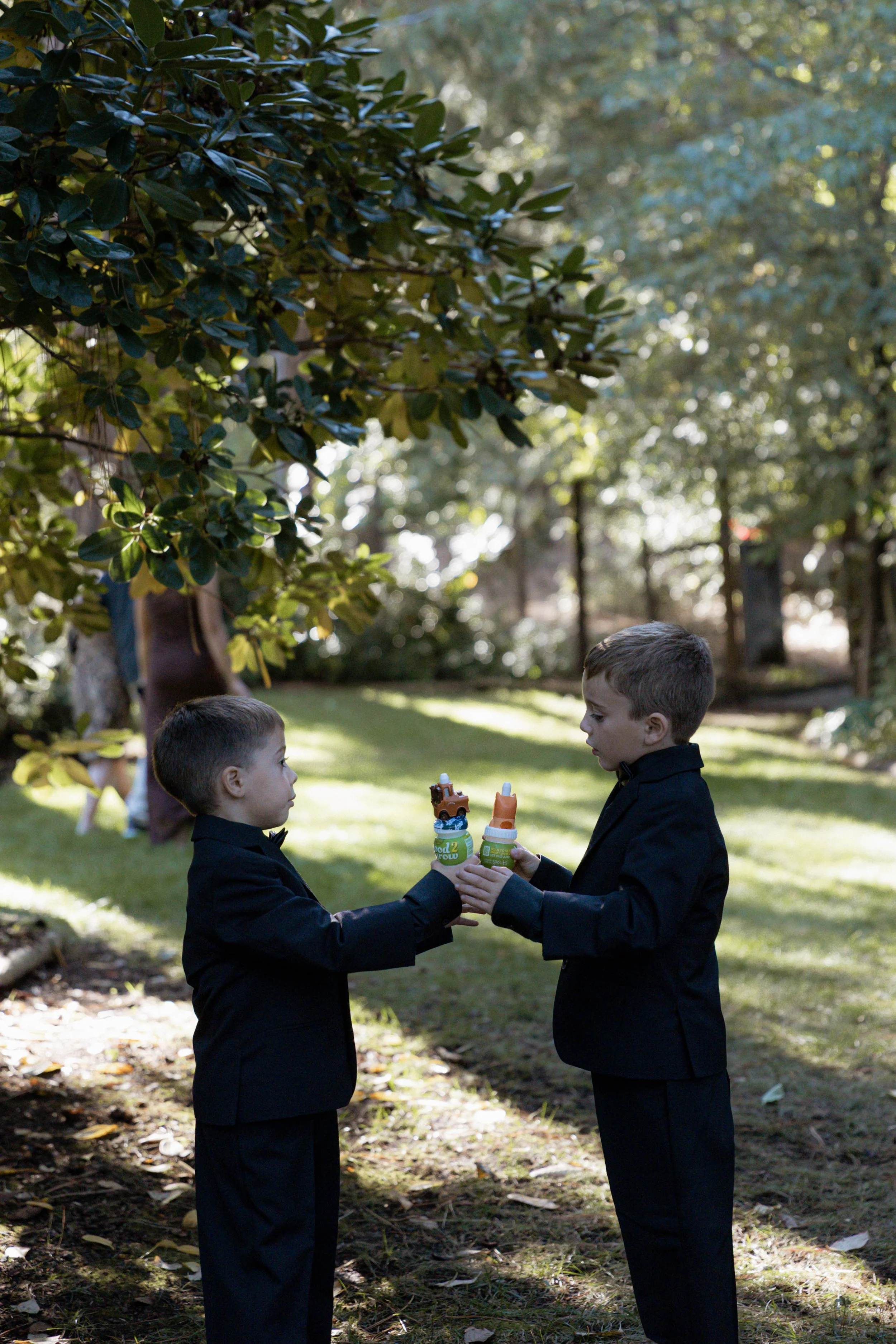 Two young boys clinking their juices at a wedding
