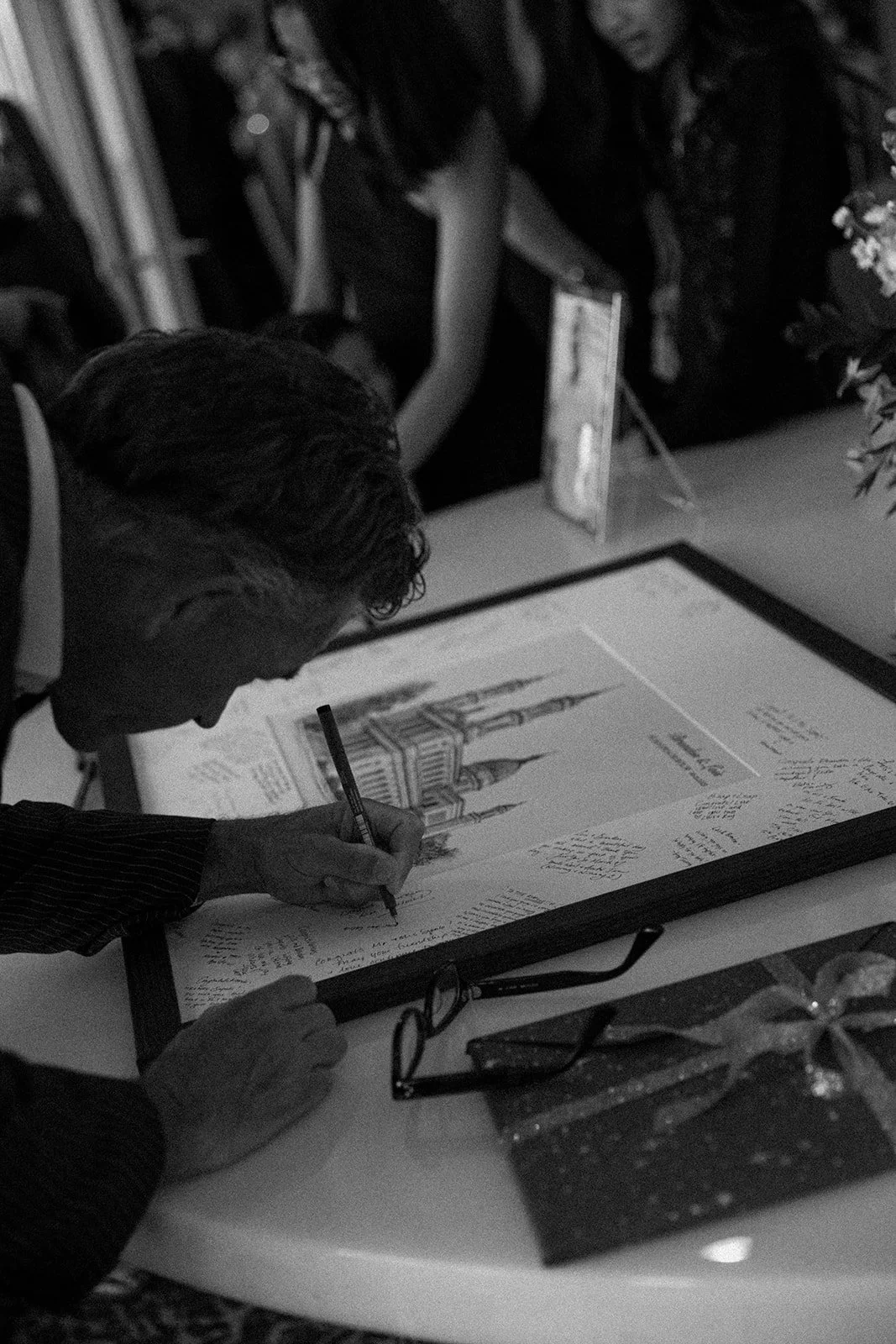 A man signing a wedding guest book