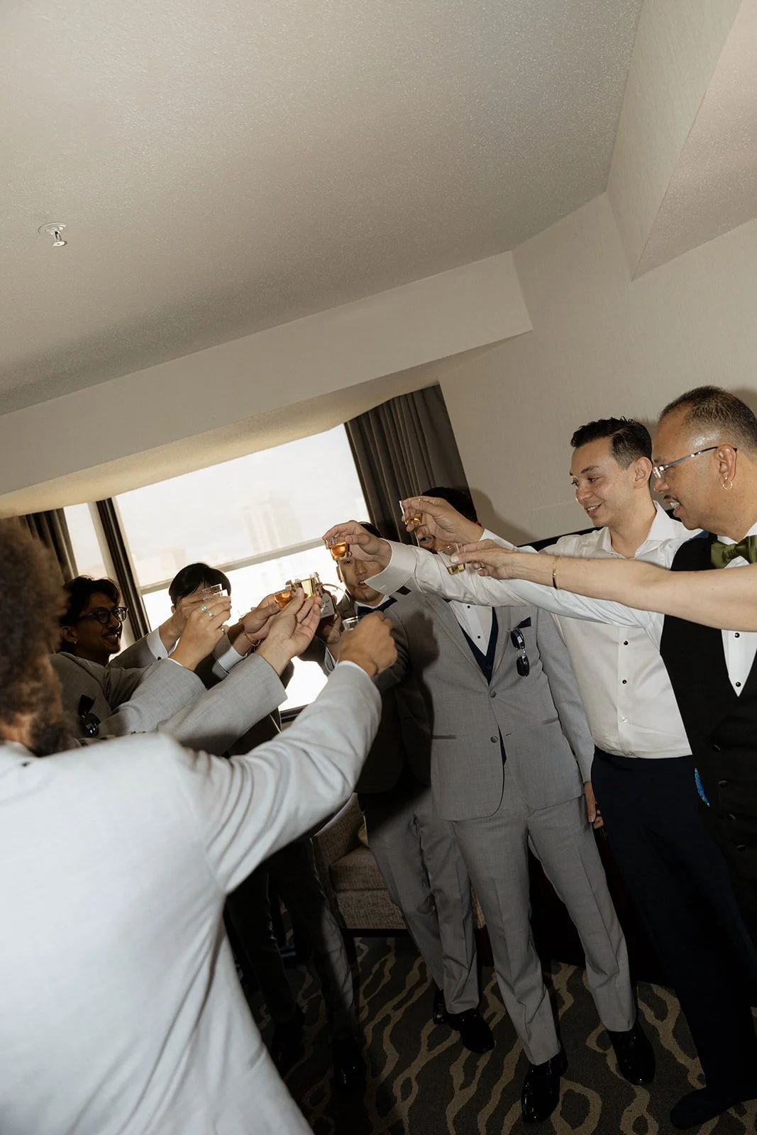 Groomsmen taking shots during the getting ready part of the day of wedding timeline