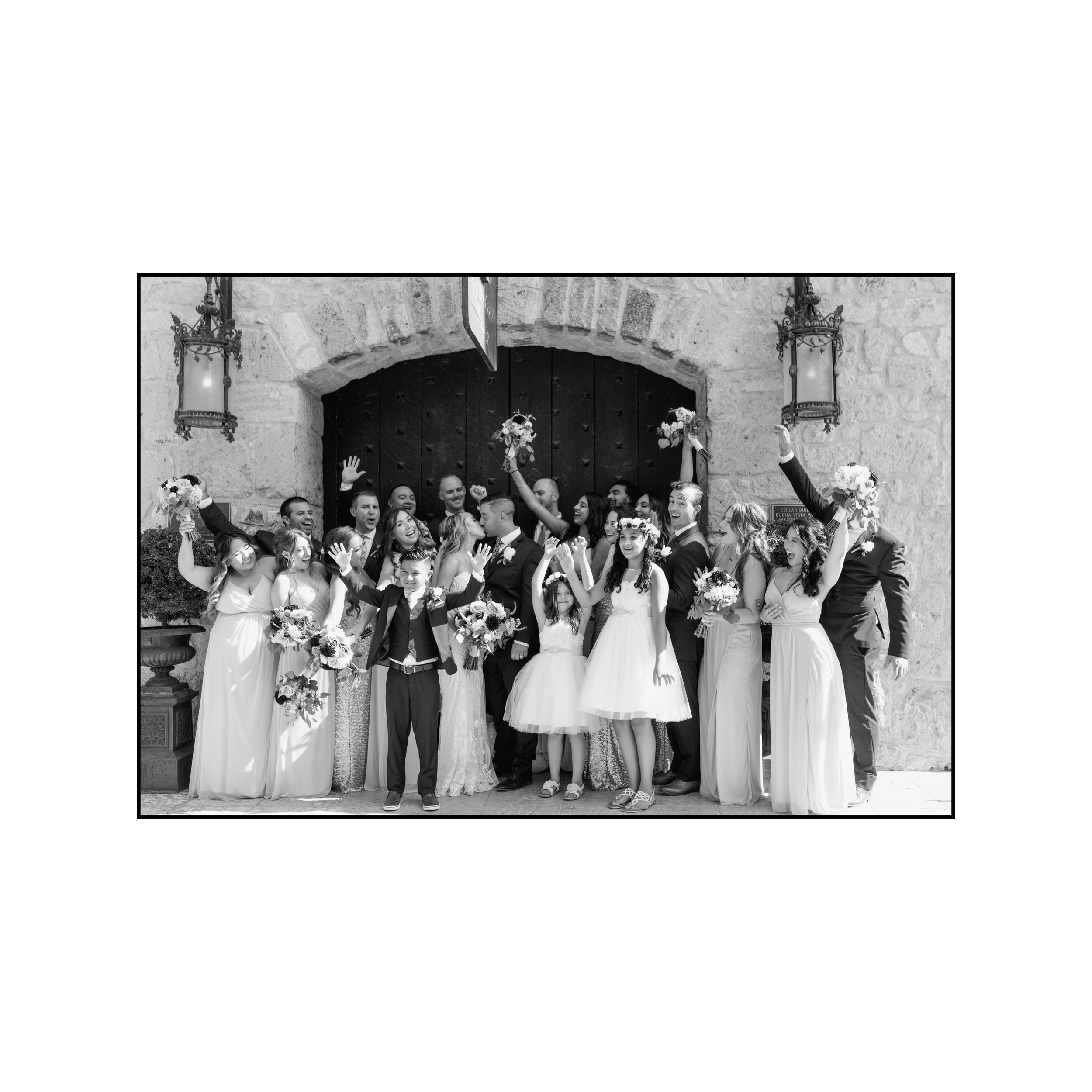 Sacramento Wedding Photographer Grand Island Mansion Wedding Photographer NorCal Wedding Photographer bride and groom reaching for each others hand  Bride and groom kissing while bridal party and groomsmen cheer them on