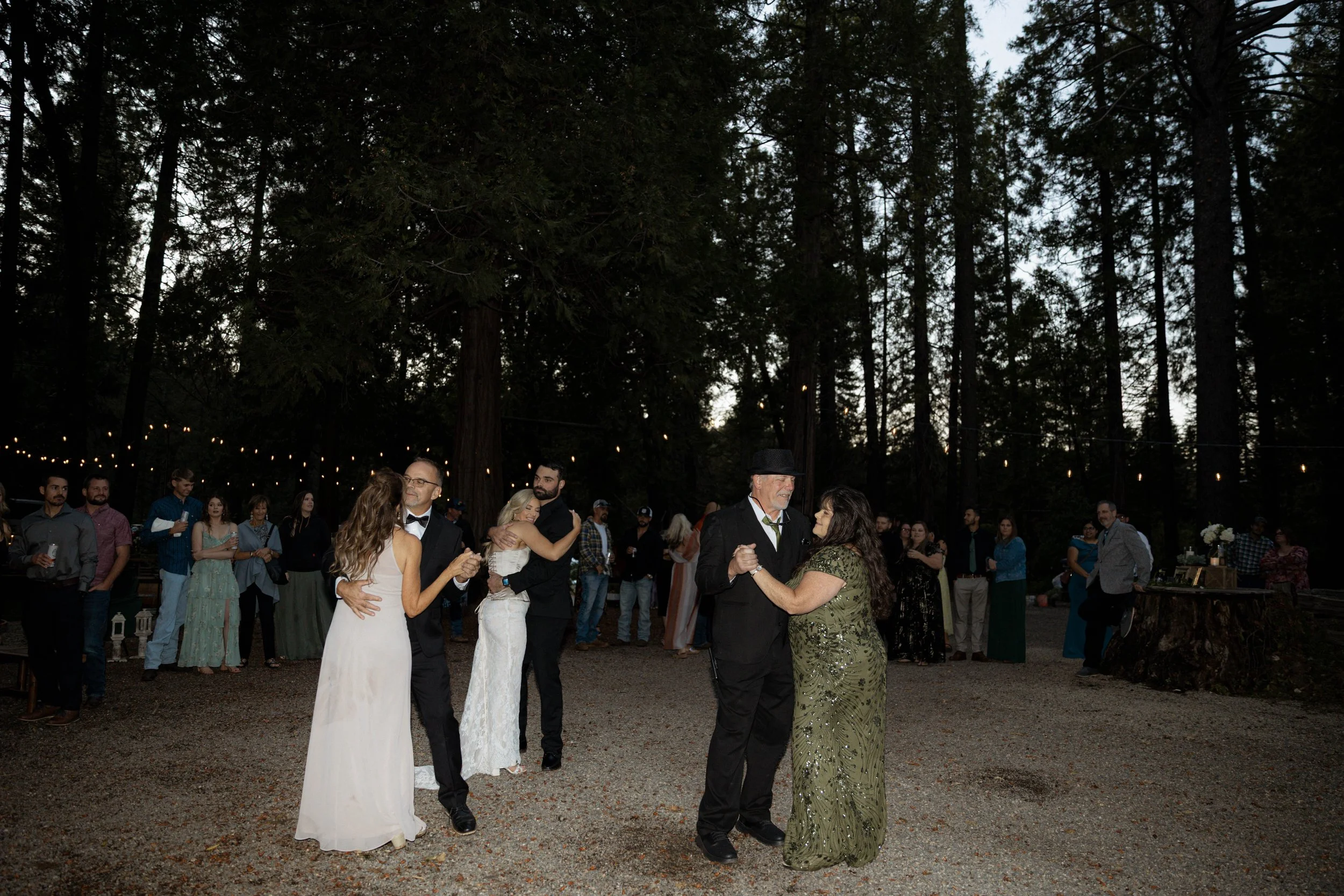 Bride and groom dancing on the dance floor at their California wedding venue with their parents dancing too