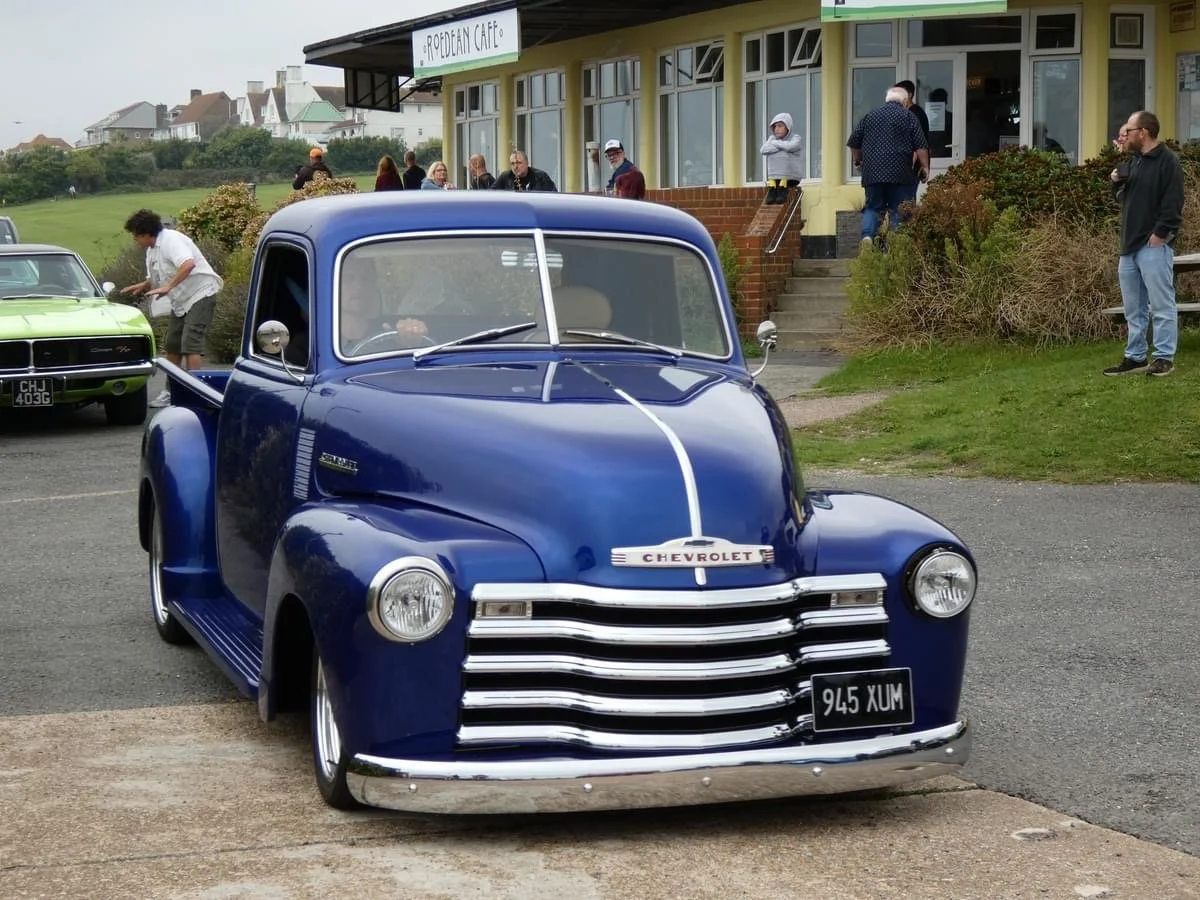 A blue vintage Chevrolet truck parked in front of Roedean Cafe