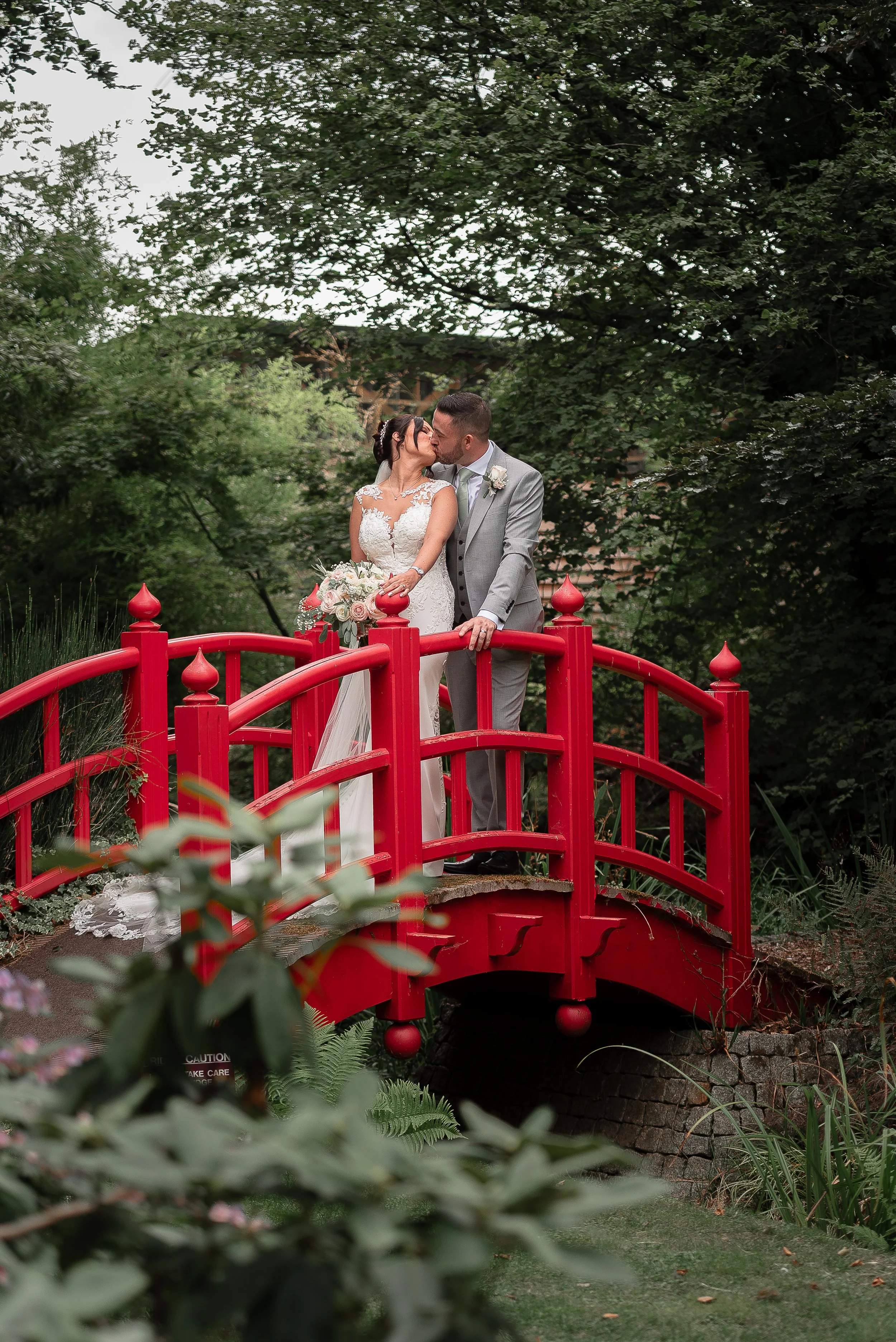 bride and groom kissing on the bridge at Rivervale Barn taken by Paul Stickland Wedding Photography, a Hampshire wedding photographer