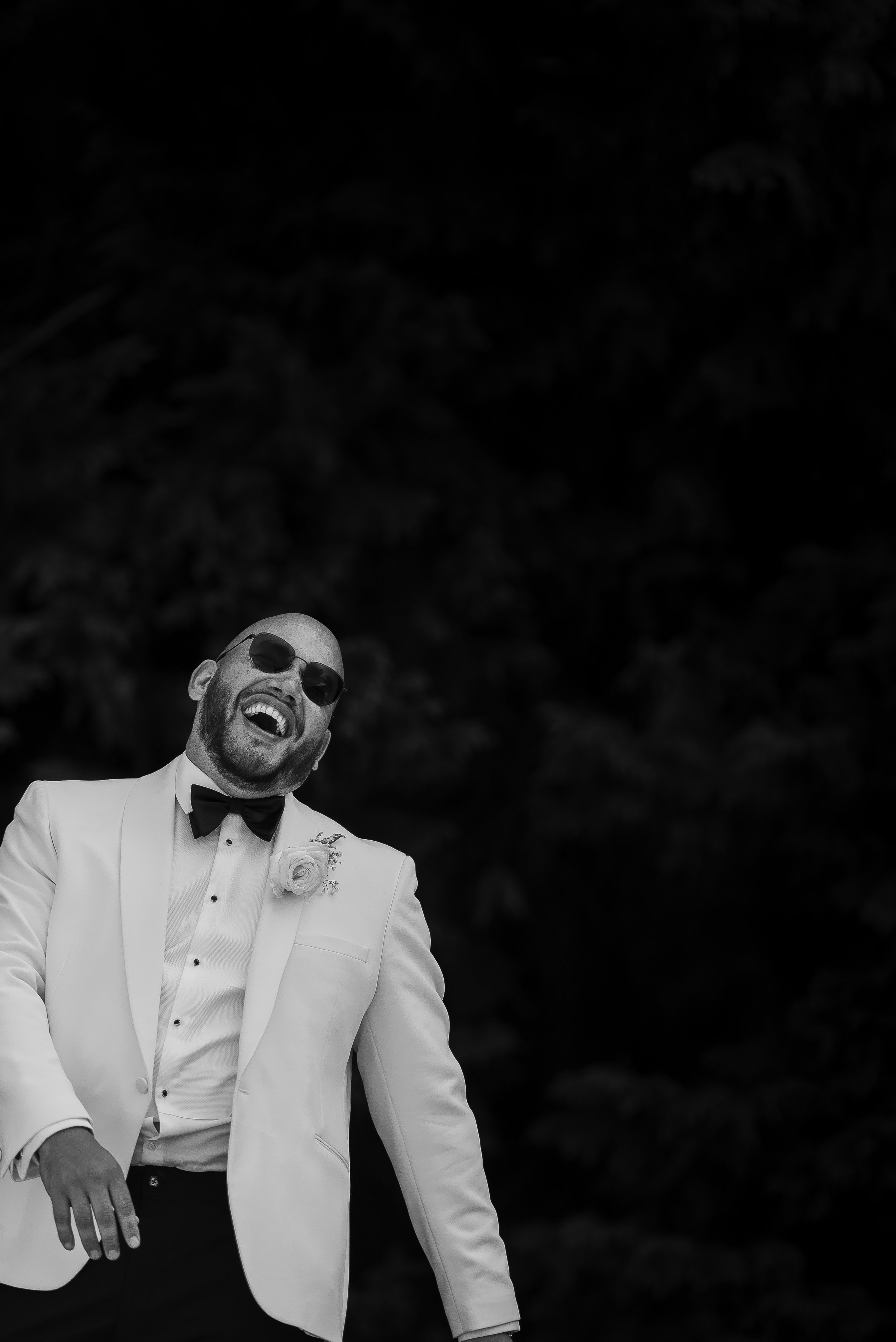 GROOM LAUGHING ON HIS WEDDING DAY. BLACK AND WHITE WEDDING PORTRAIT TAKEN BY PAUL STICKLAND WEDDING PHOTOGRAPHER,
 A HAMPSHIRE WEDDING PHOTOGRAPHER