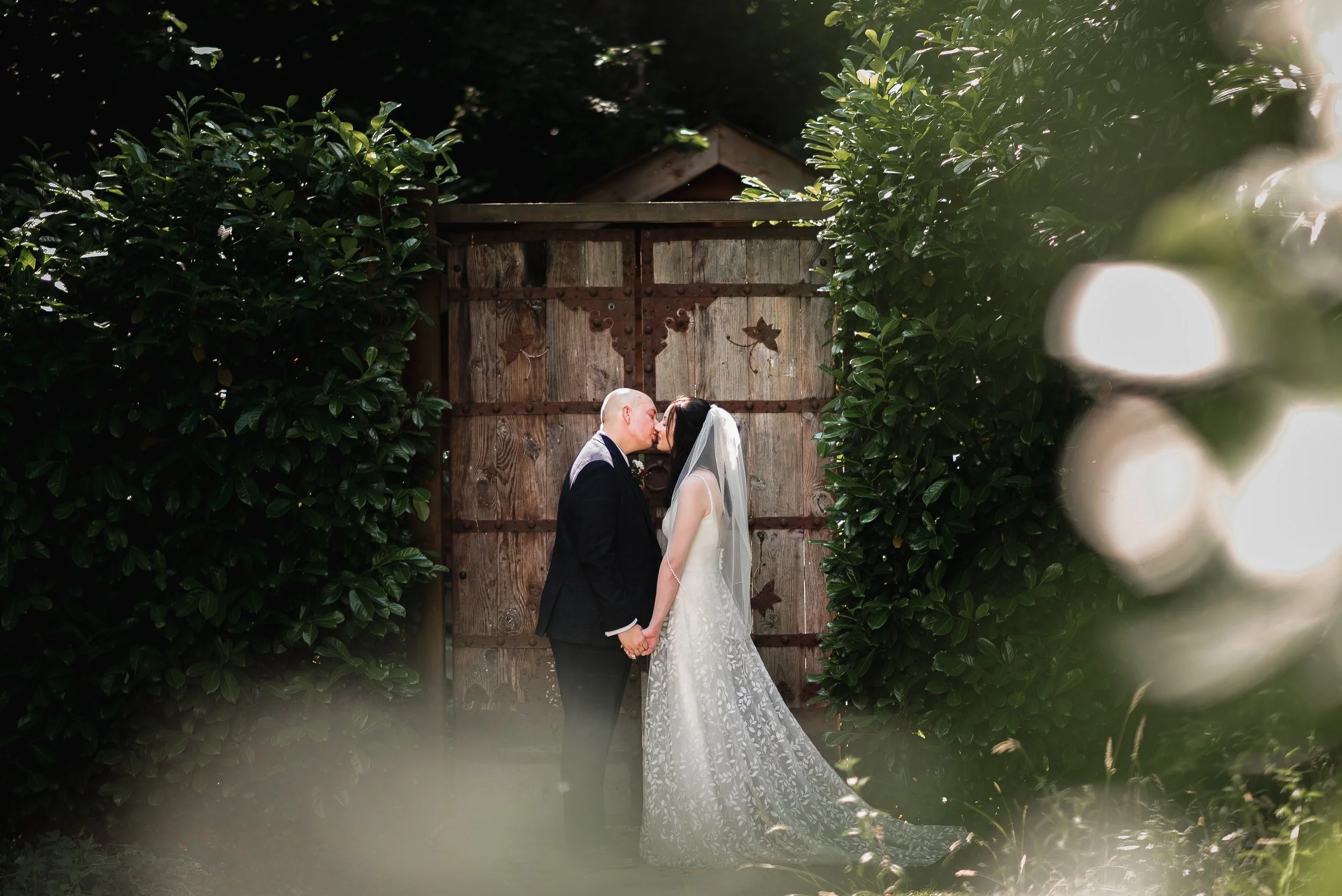 bride and groom kissing in the garden of Millbrook House after getting married