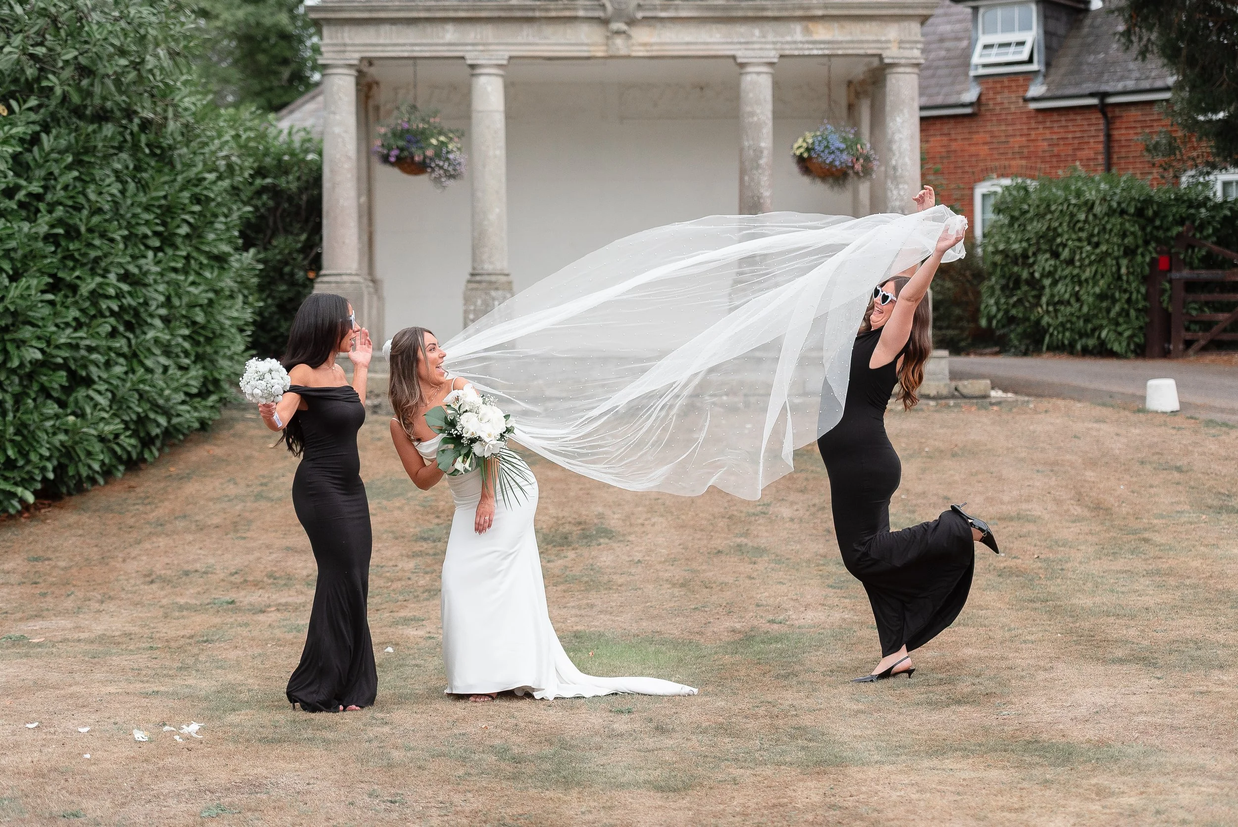 Hampshire wedding photography of bridesmaid throwing the veil in the air taken by Paul Stickland Wedding Photography