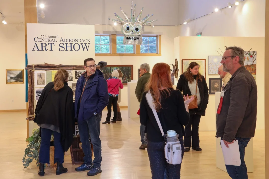 Gallery visitors admiring art works from the 75th annual Central Adirondack Art Show