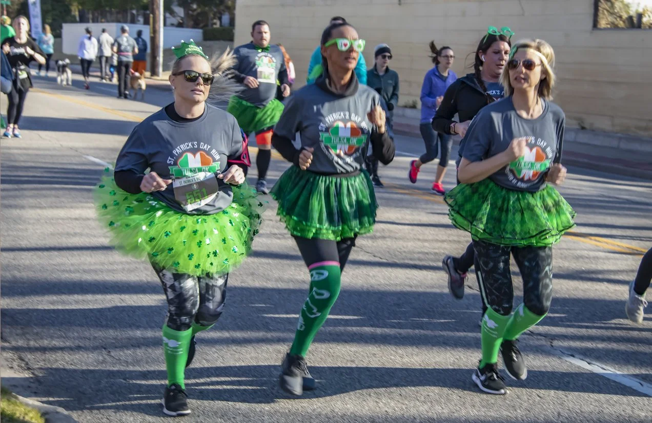 Women running in St. Patrick's Day costumes in a race like the Shamrock Shuffle in Glens Falls.