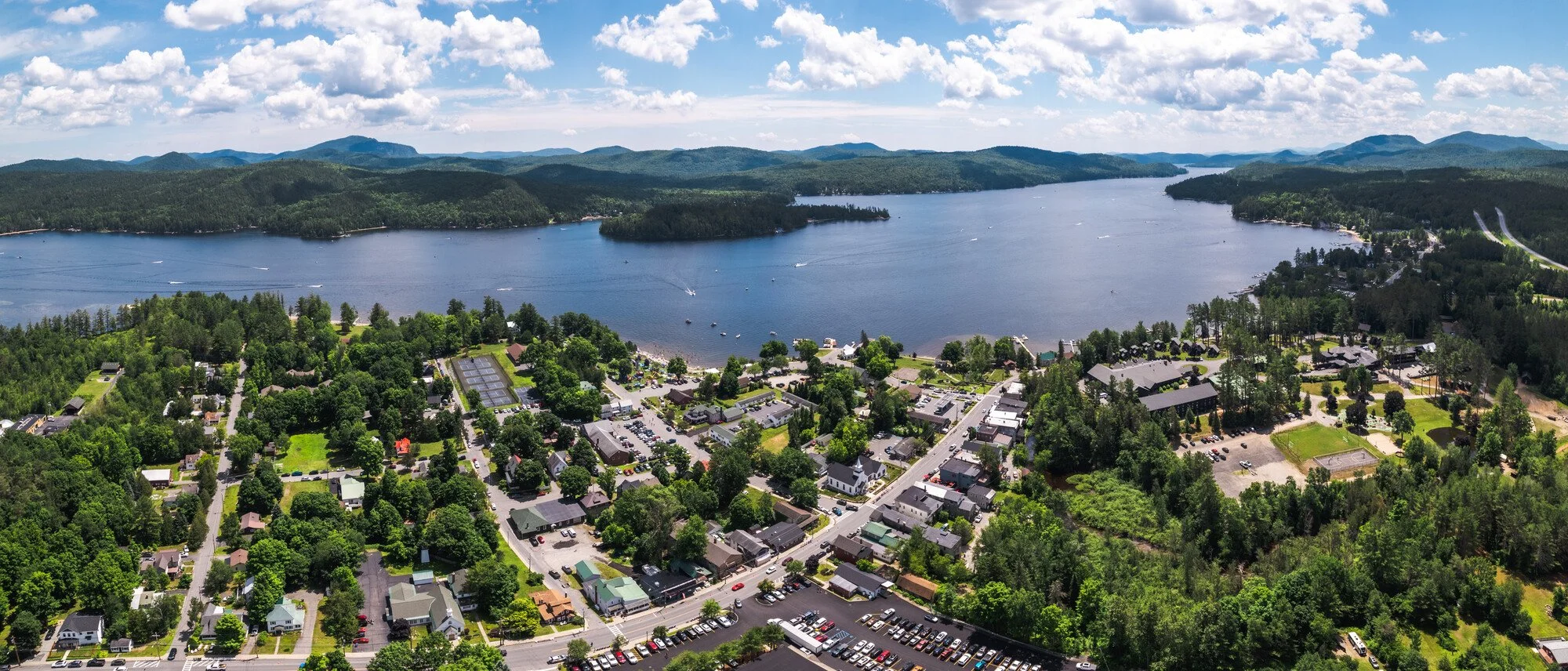 Aerial view of Schroon Lake village in the summer with boats on the lake.