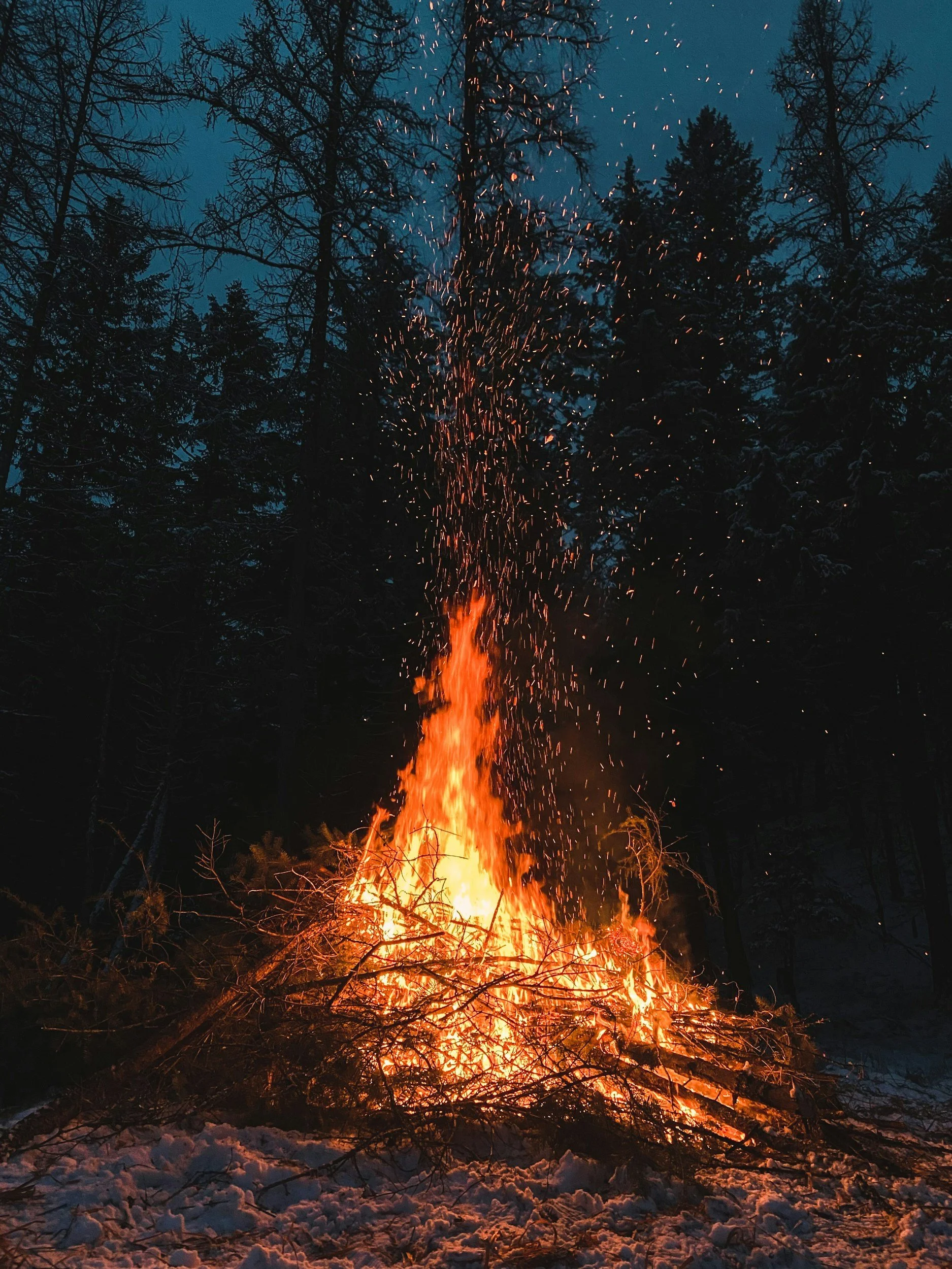Warming bonfire on a snowy night evoking the fires along the trails at Mt. Van Hoevenberg.