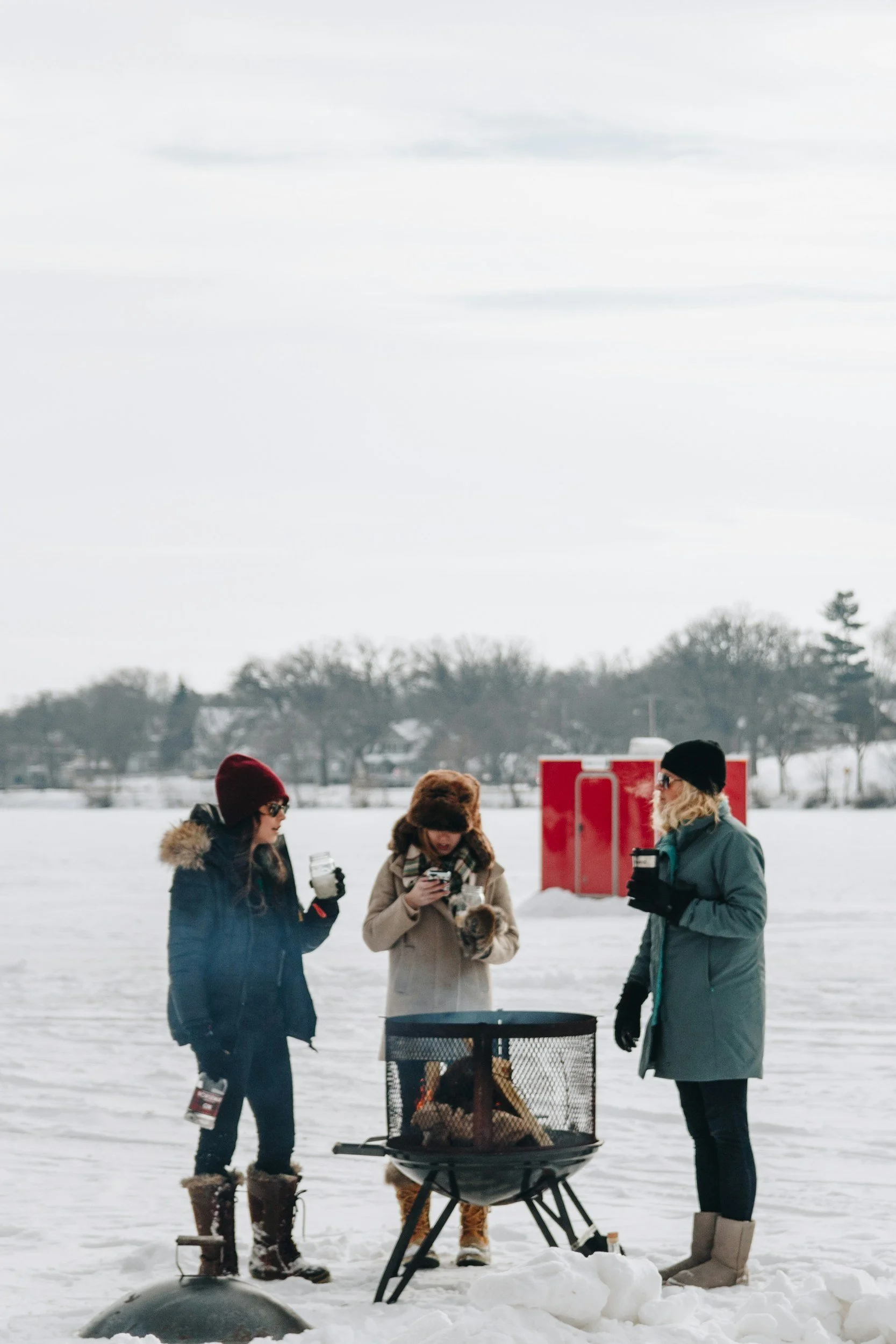People gathered together while ice fishing reminiscent of the Mike Norris Ice Fishing Derby community spirit on Raquette Lake.