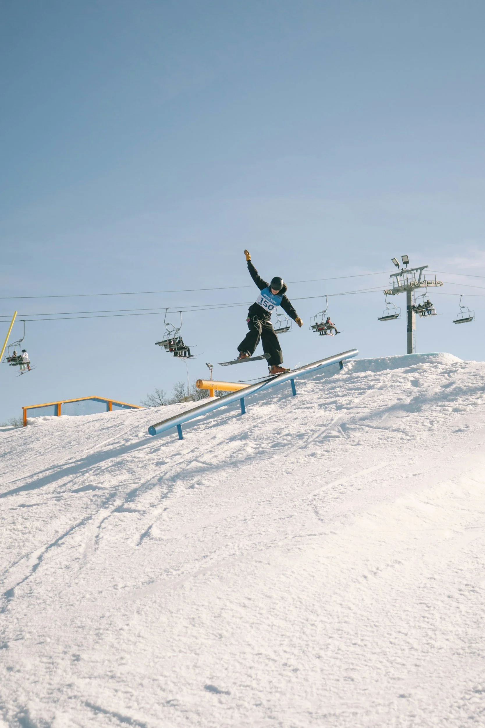 skier performing tricks on ski rail.
