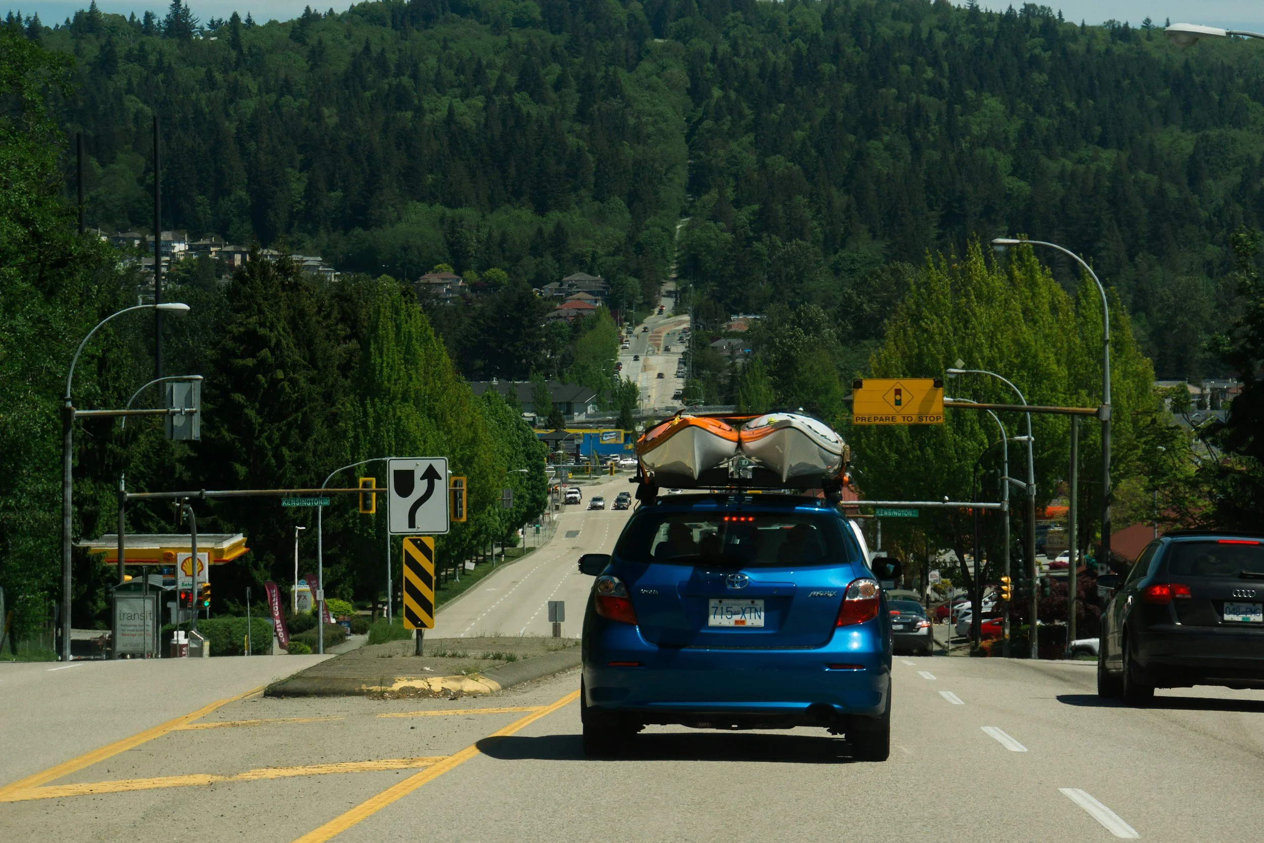Kayaks atop car heading north to the Adirondacks to begin the summer season.