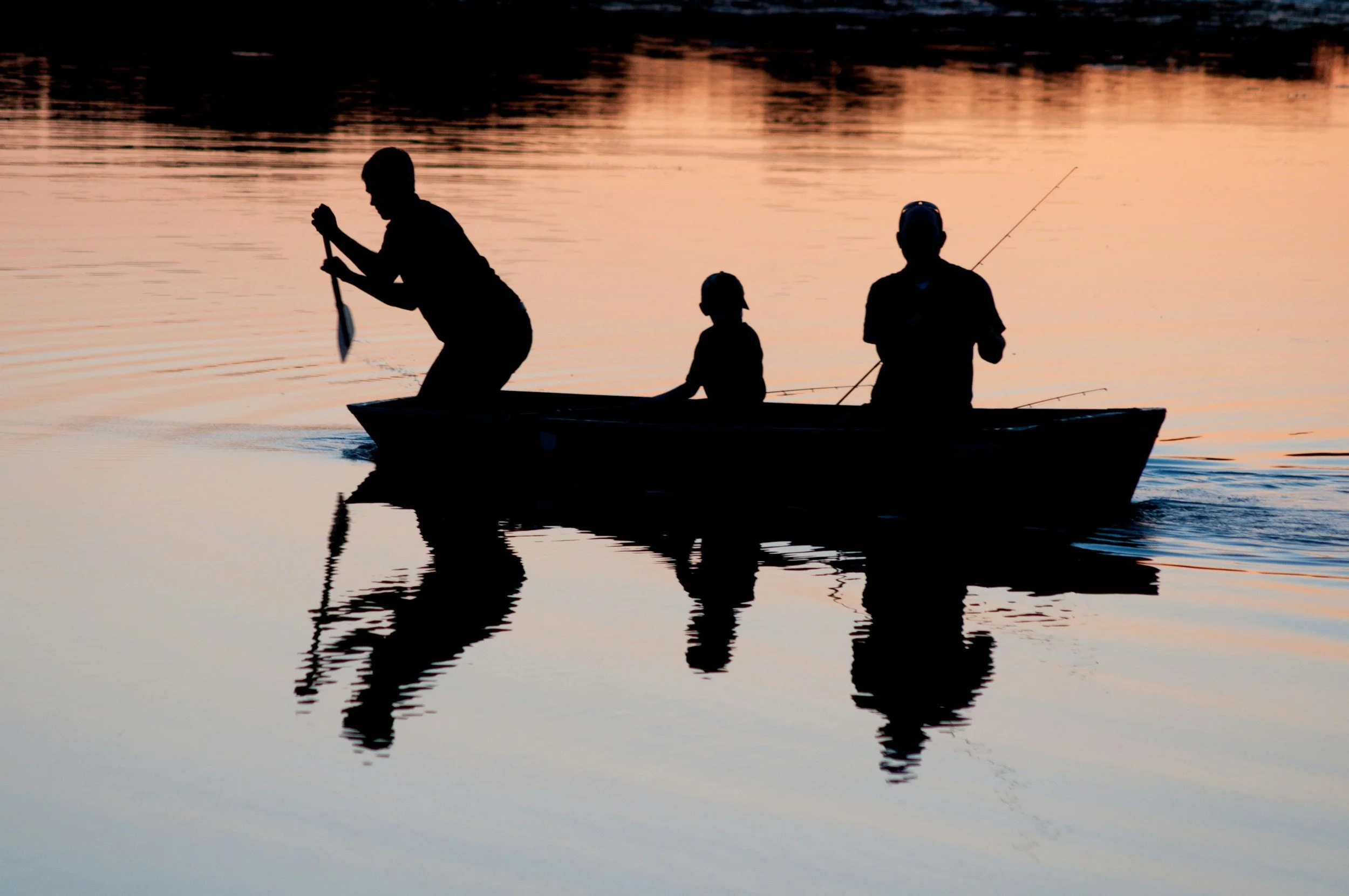 A family in a boat on an Adirondack lake fishing.