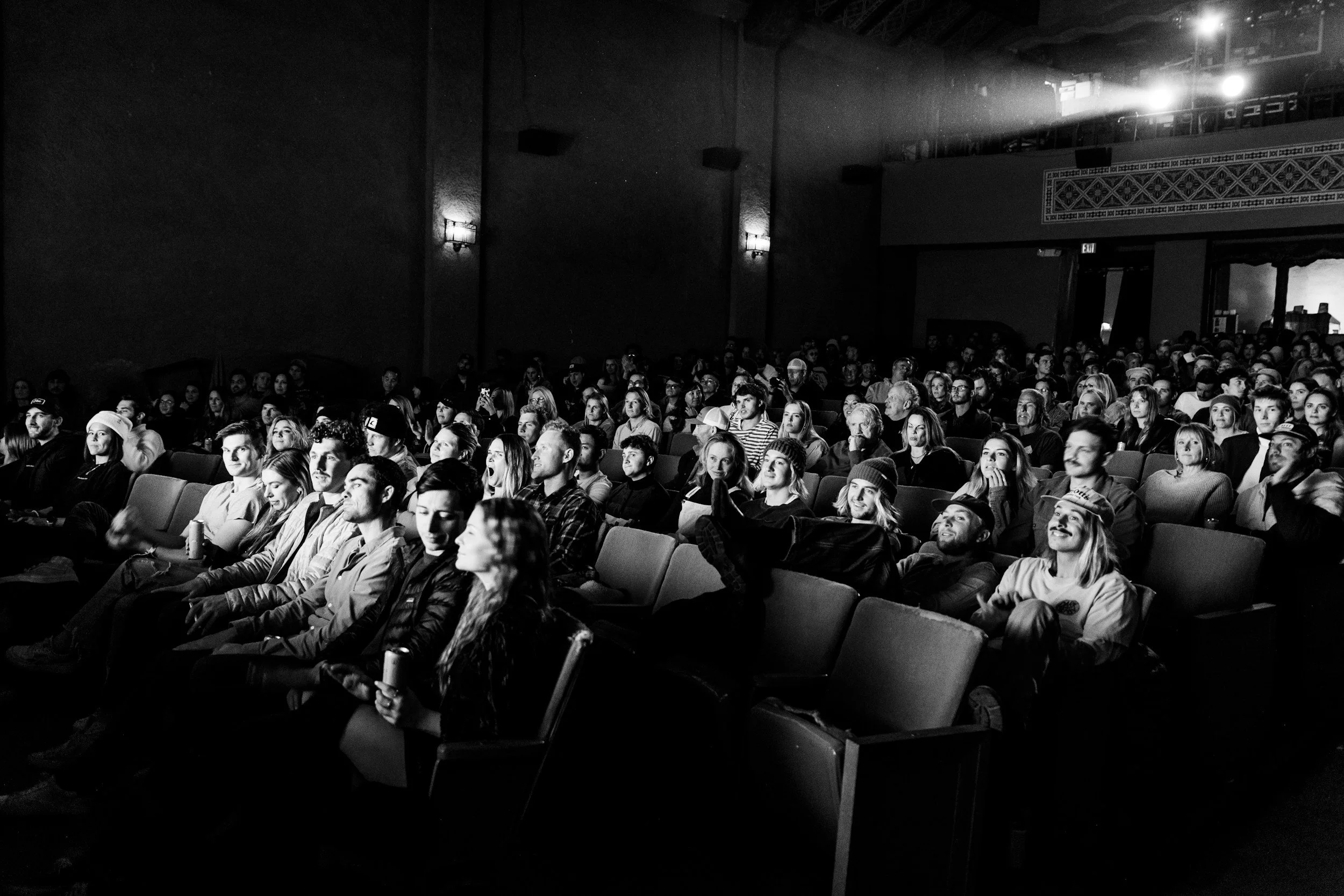 Crowd of people enjoying a movie in a classic theater.