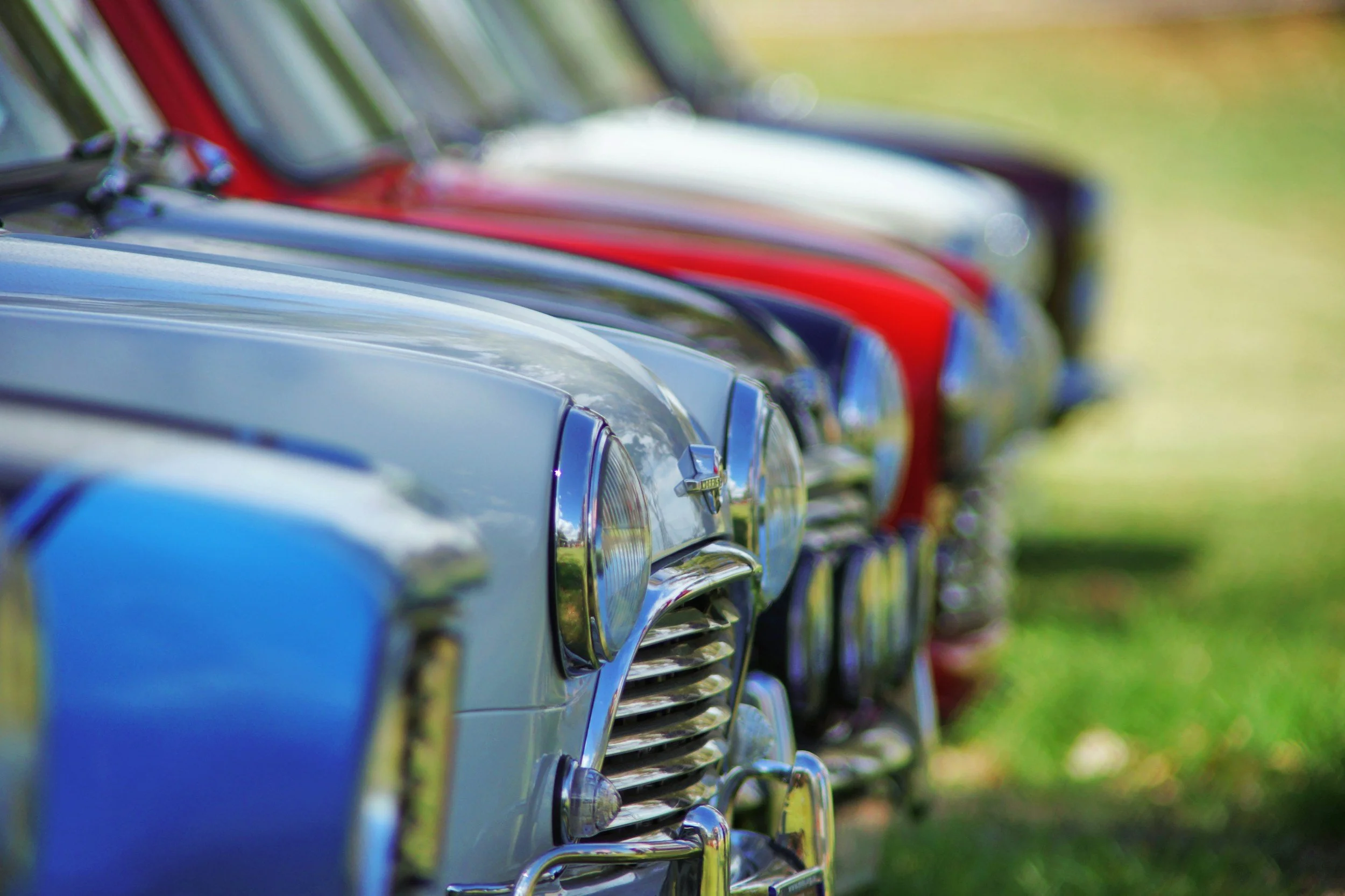 Vintage cars lined up at a car show.