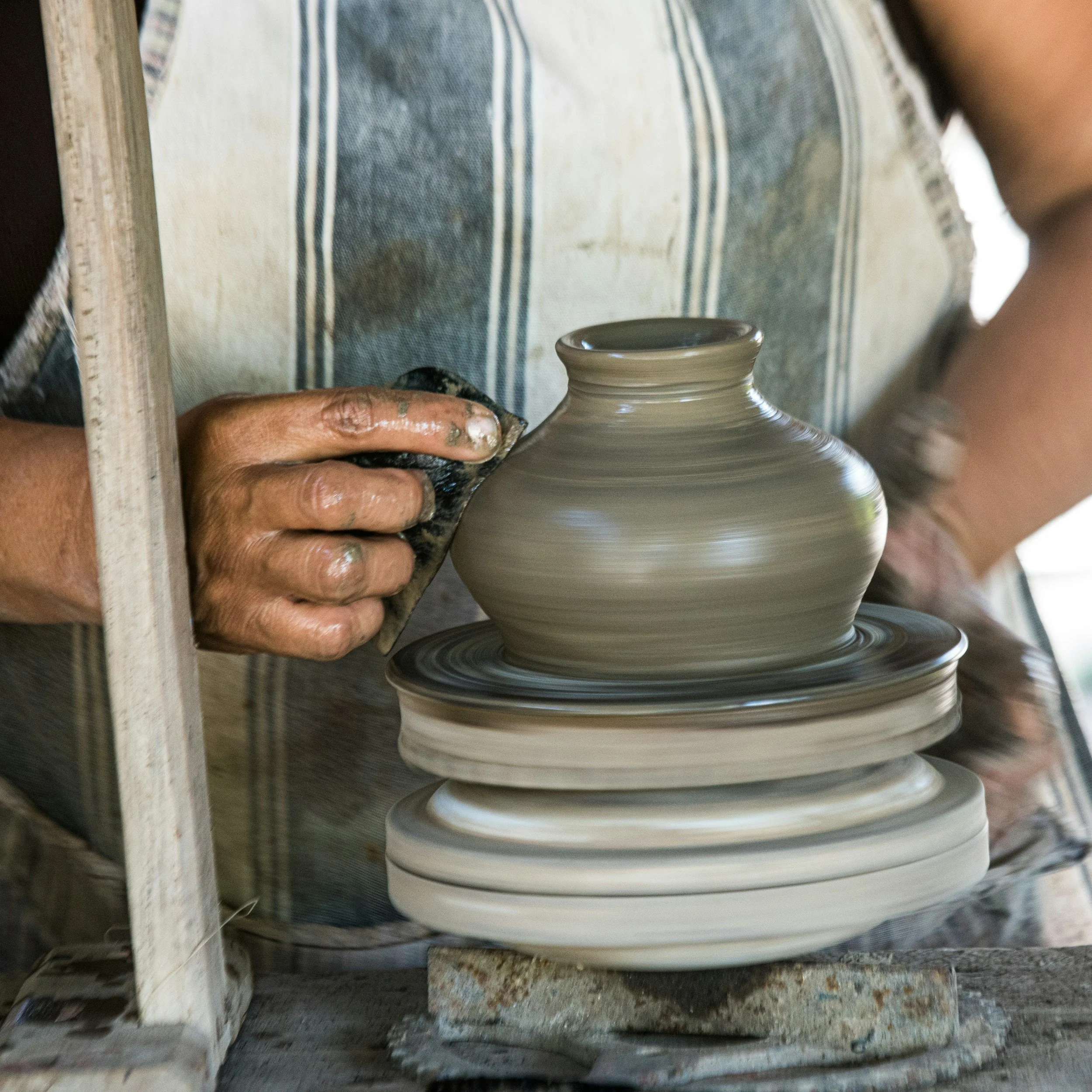 Artist crafting pottery by hand.