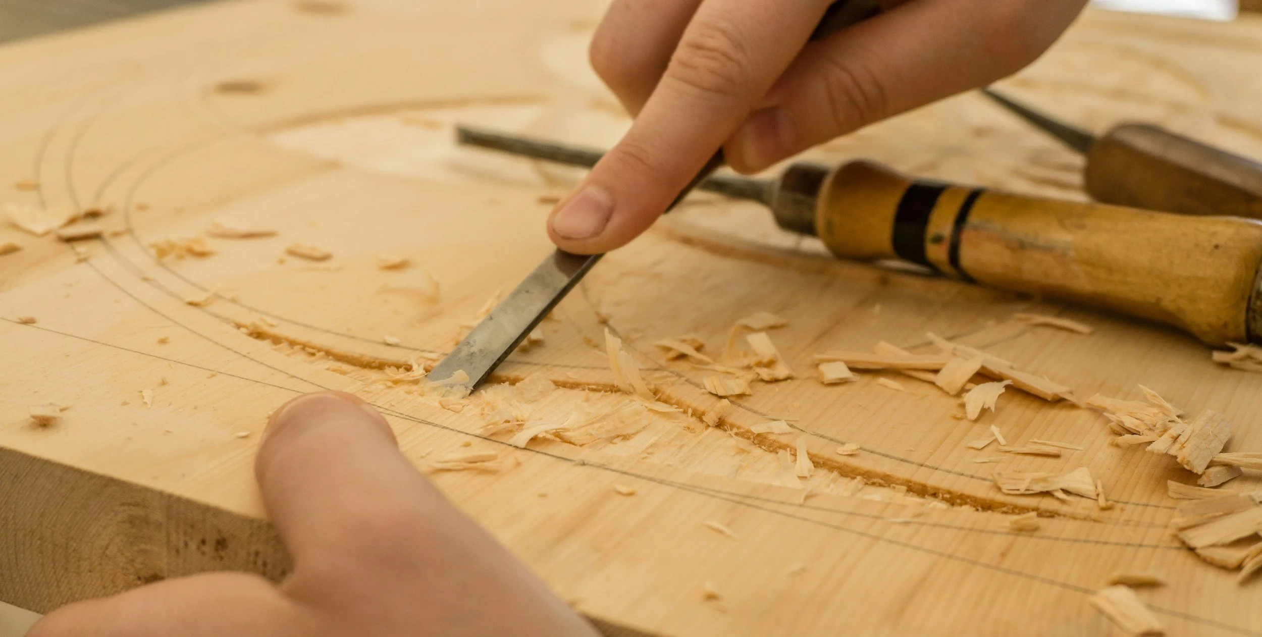 Carving by hand in wood to make artwork.