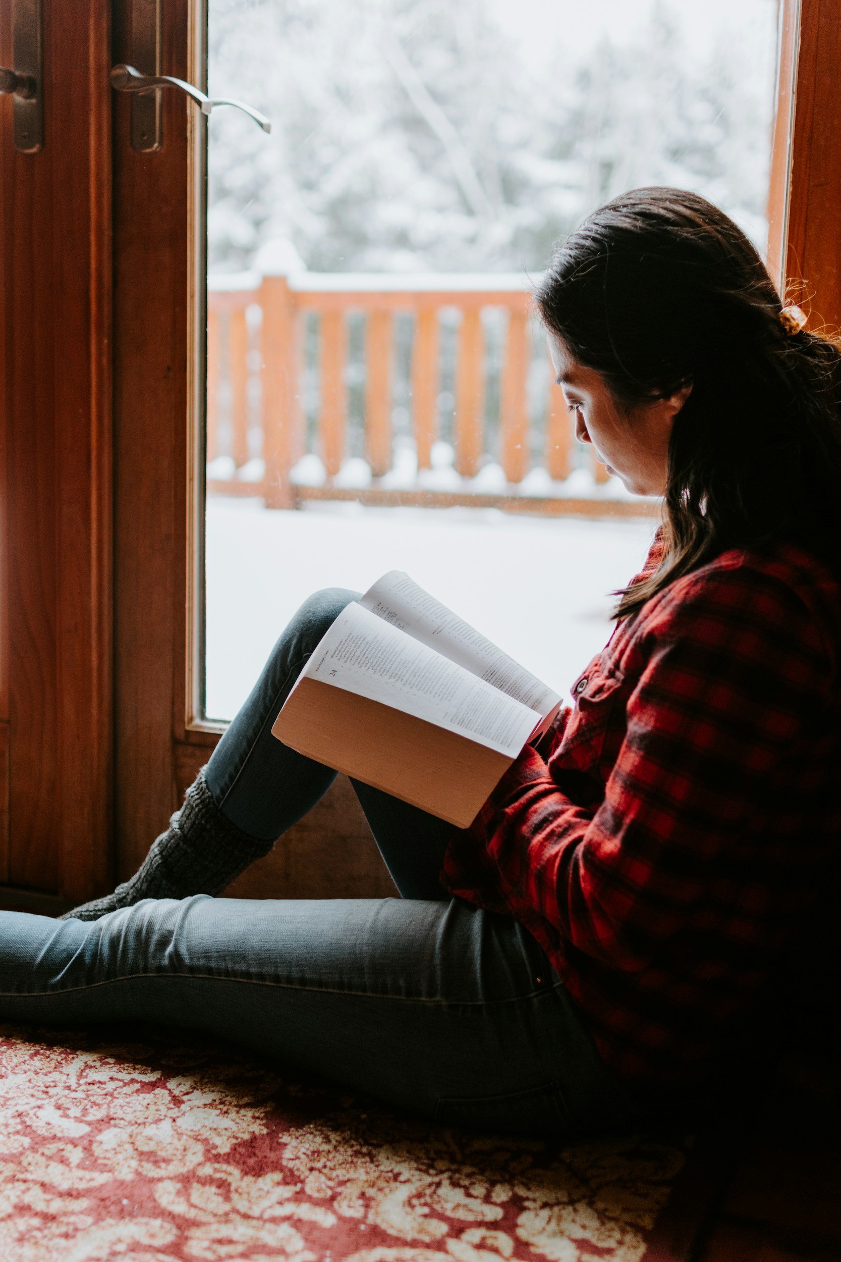 Young adult or teenager reading a book.