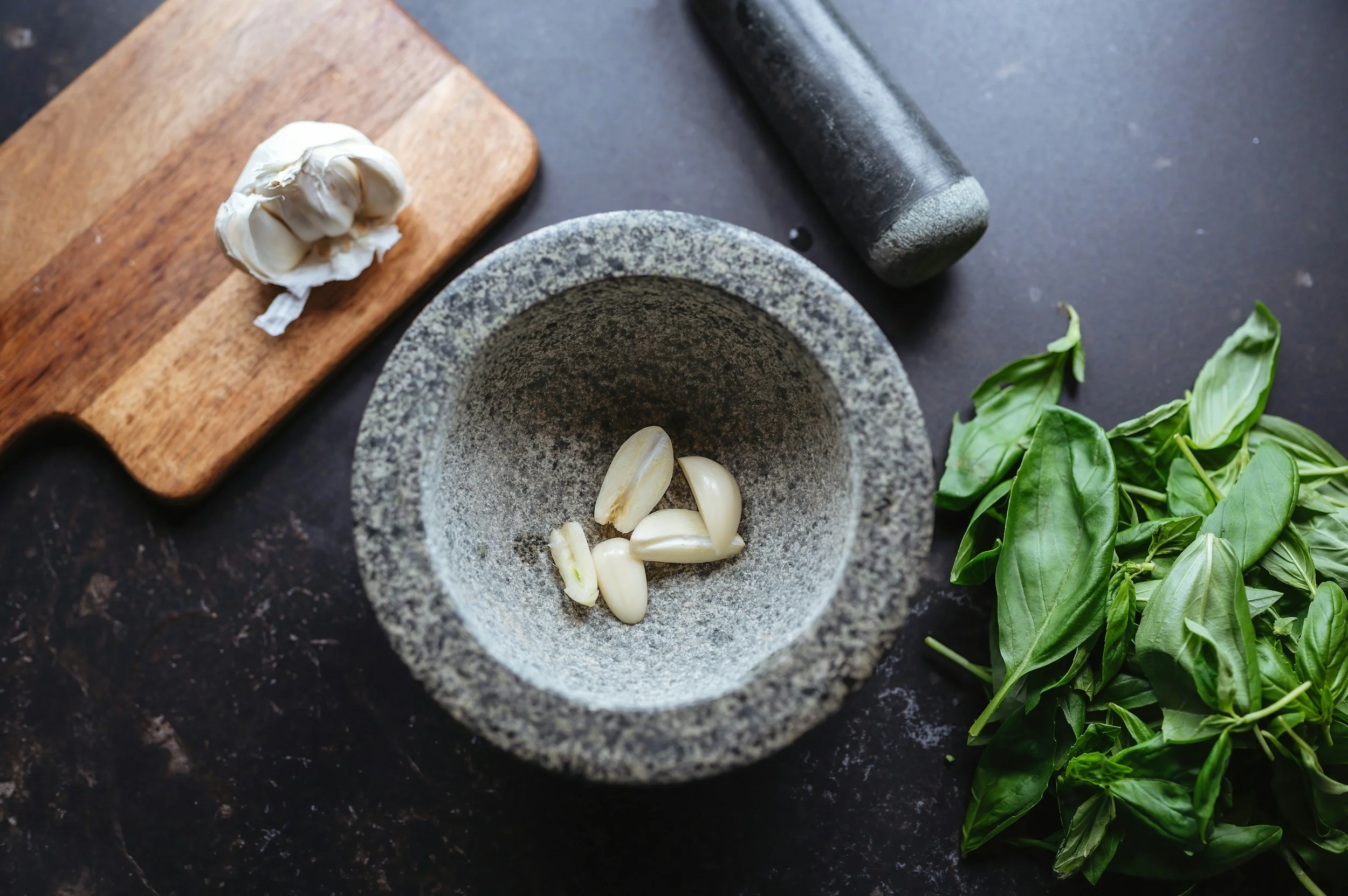 garlic in mortar and pestle in a cooking demonstration.