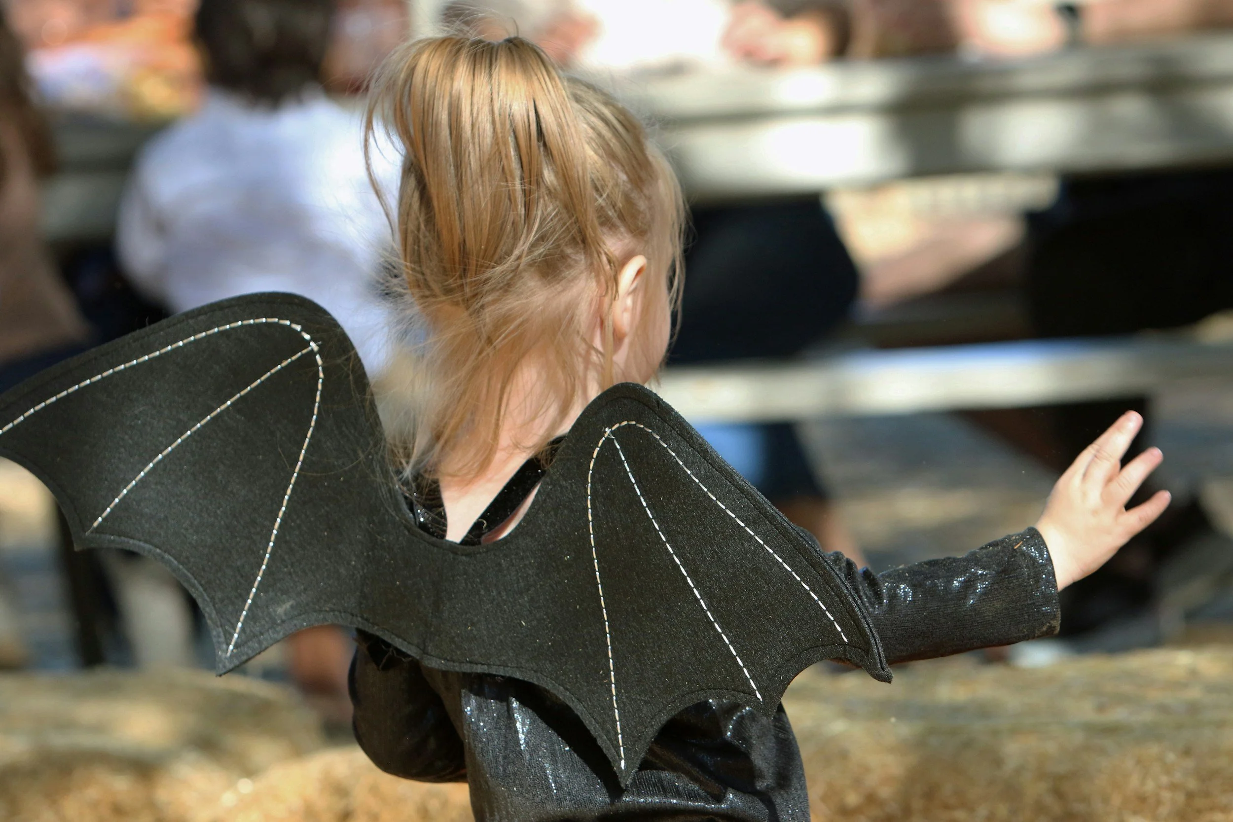 girl in halloween costume featuring bat wings.