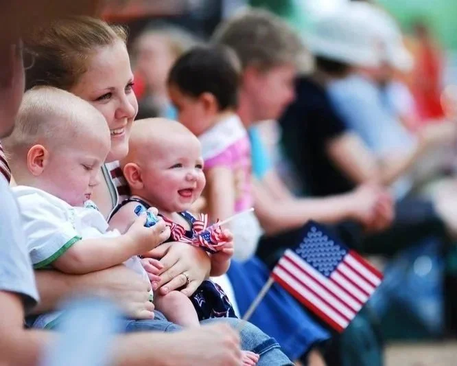 mother with twin babies watching schroon lake's annual 4th of July parade.