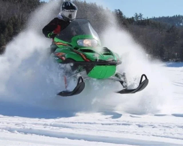 Snowmobile powering thru snow in Old Forge at SnoFest.
