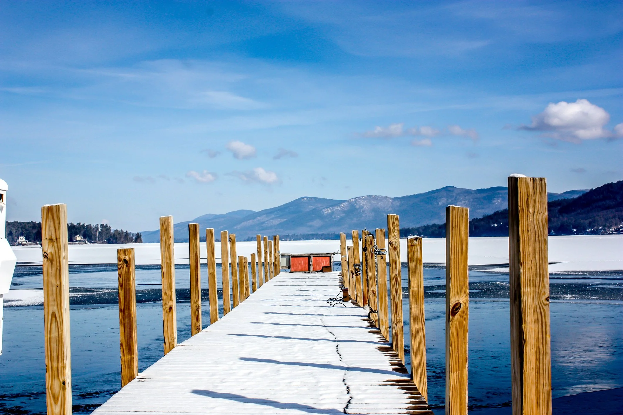 Dock stretching into the icy waters of Lake George in the Winter.