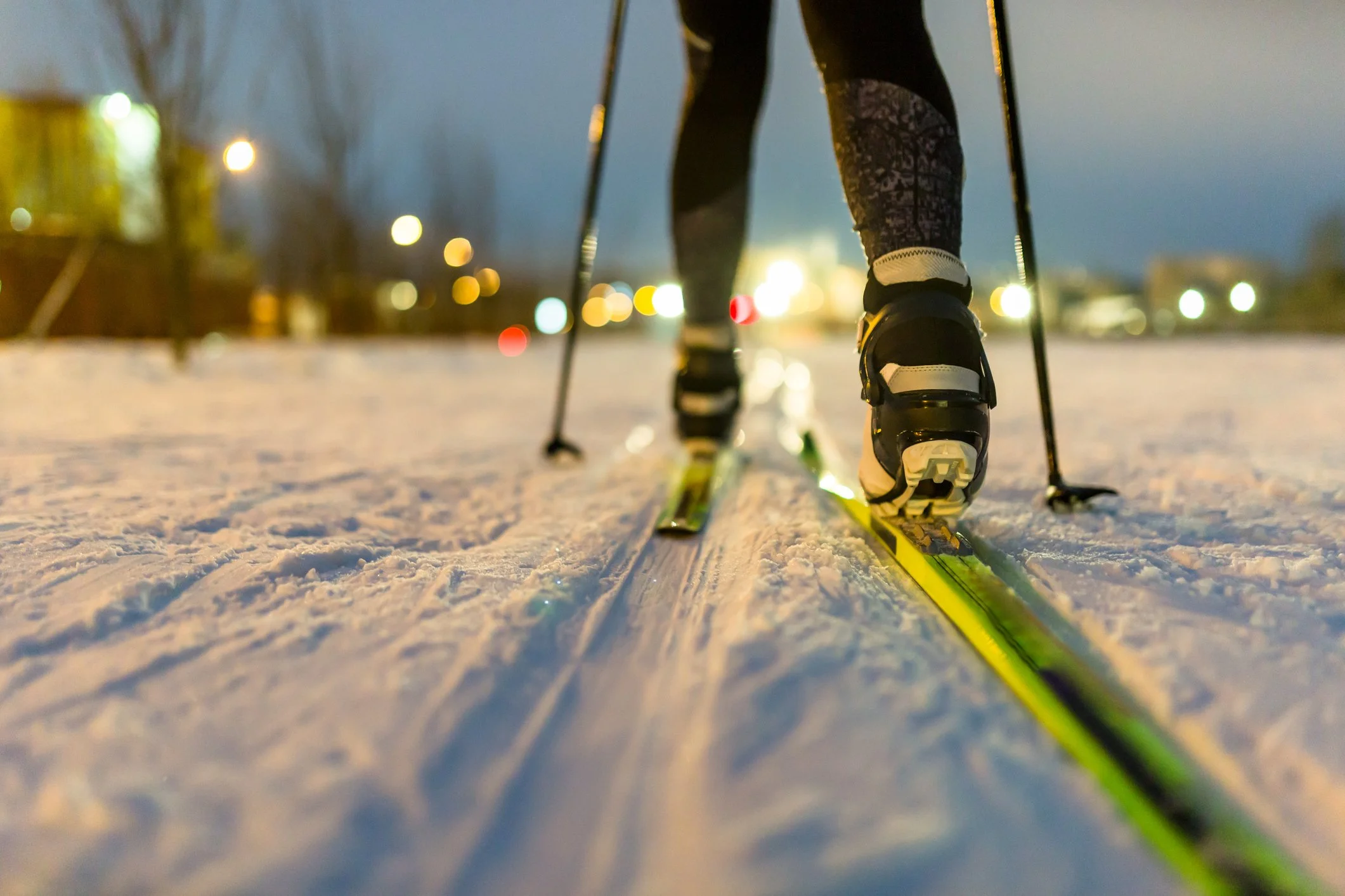 Close-up of XC skier's legs as she glides over snow.