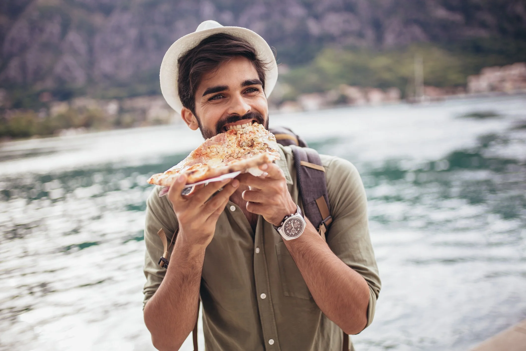 Man eating pizza on a boat.