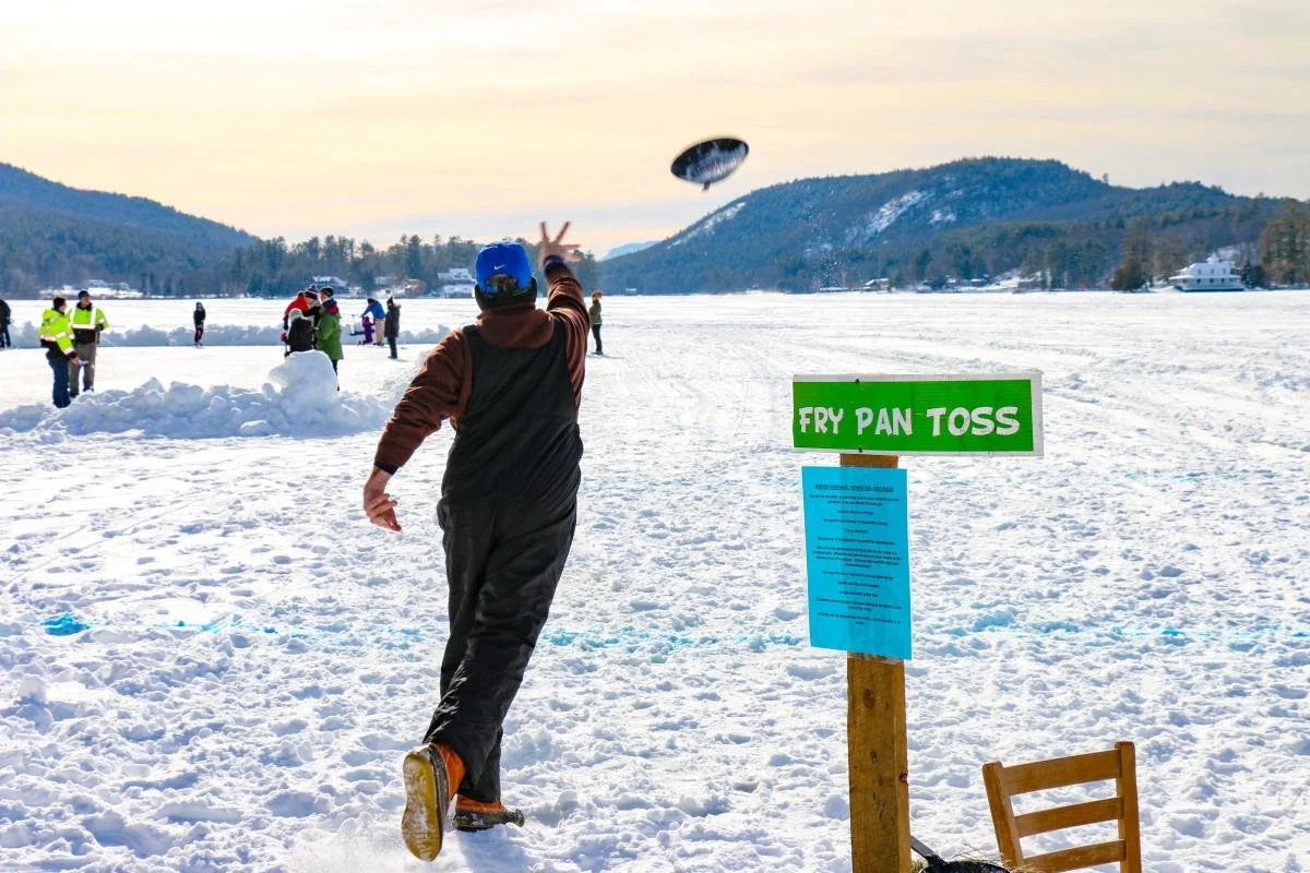 Person tossing a frying pan at Brant Lake's Winter Carnival.