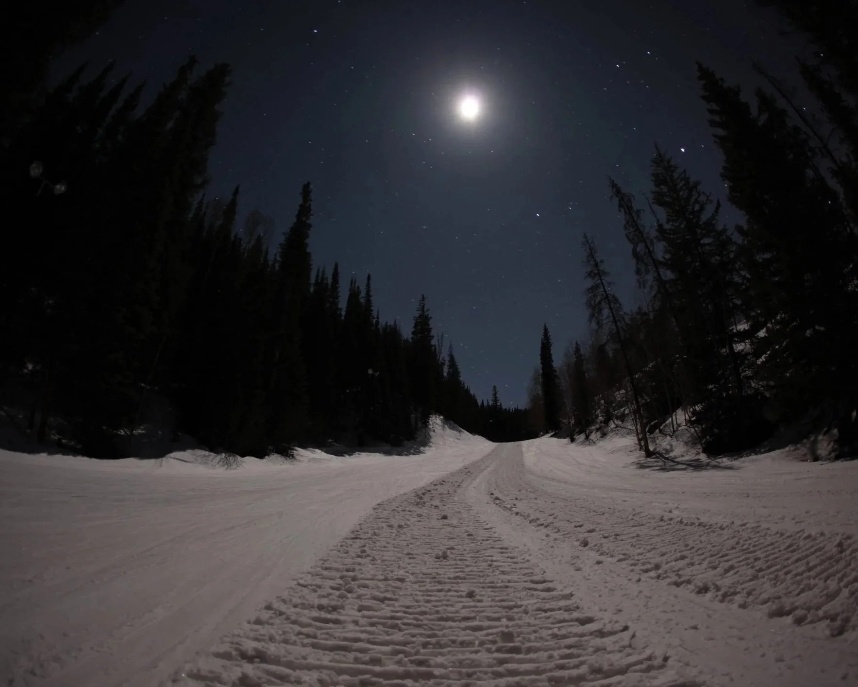 Moonlit ski trail under a full moon.