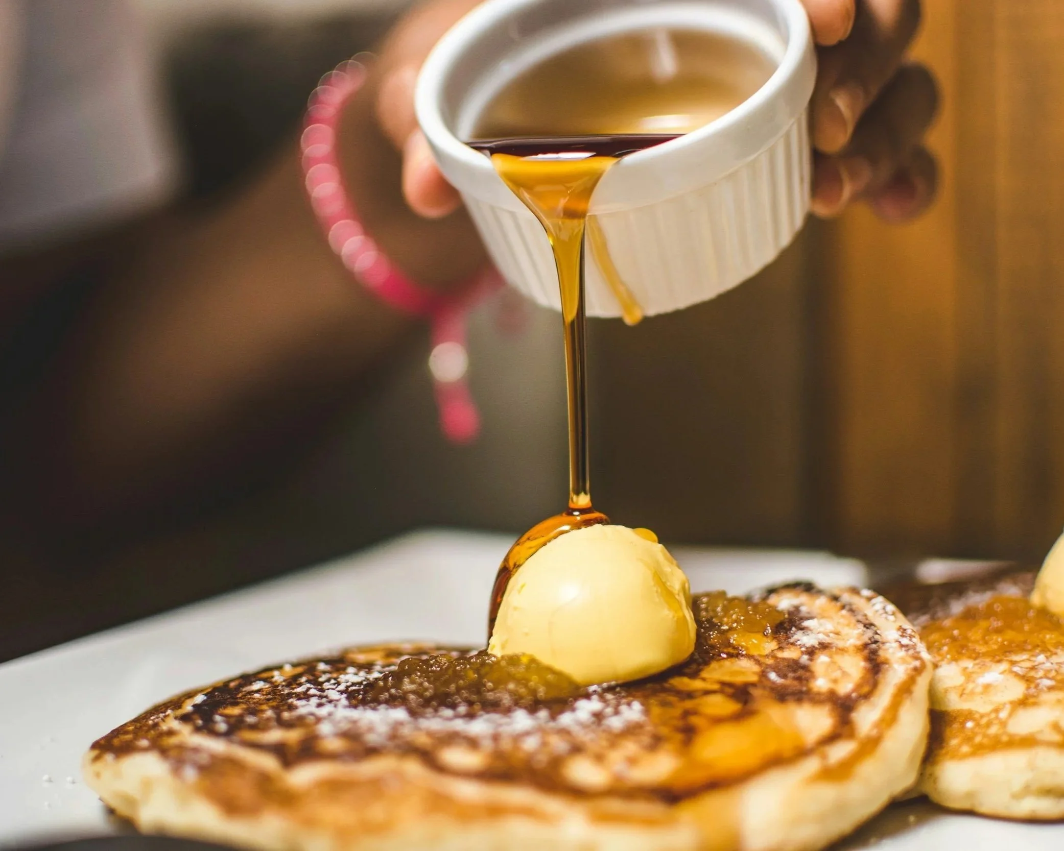 Pure Adirondack maply syrup poured over pancakes.