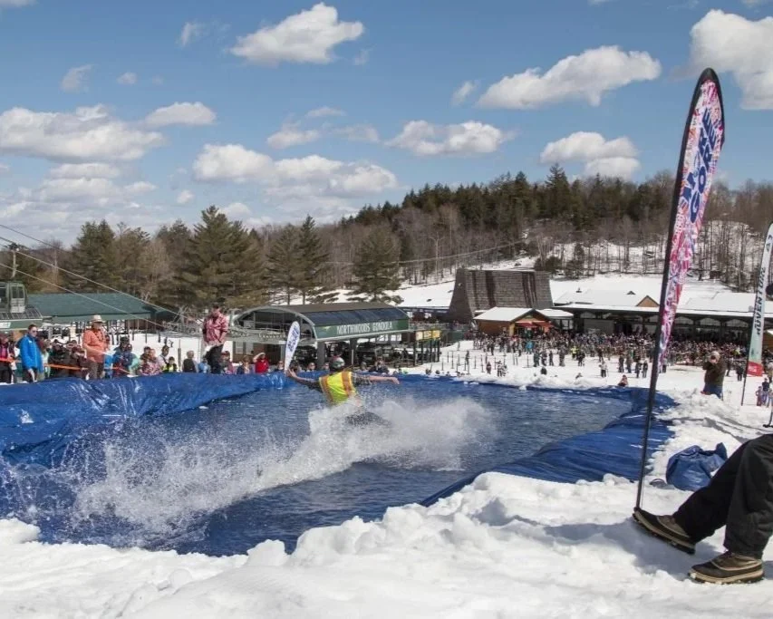 Competitors splash down at Gore Mountain's annual pond skimming competition.