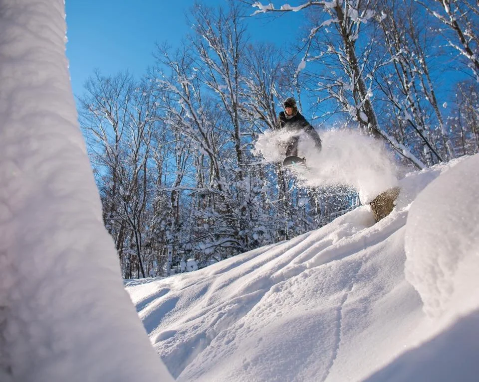Skier shredding inches of fresh powder at Snow Ridge Ski Resort in Turin, NY.