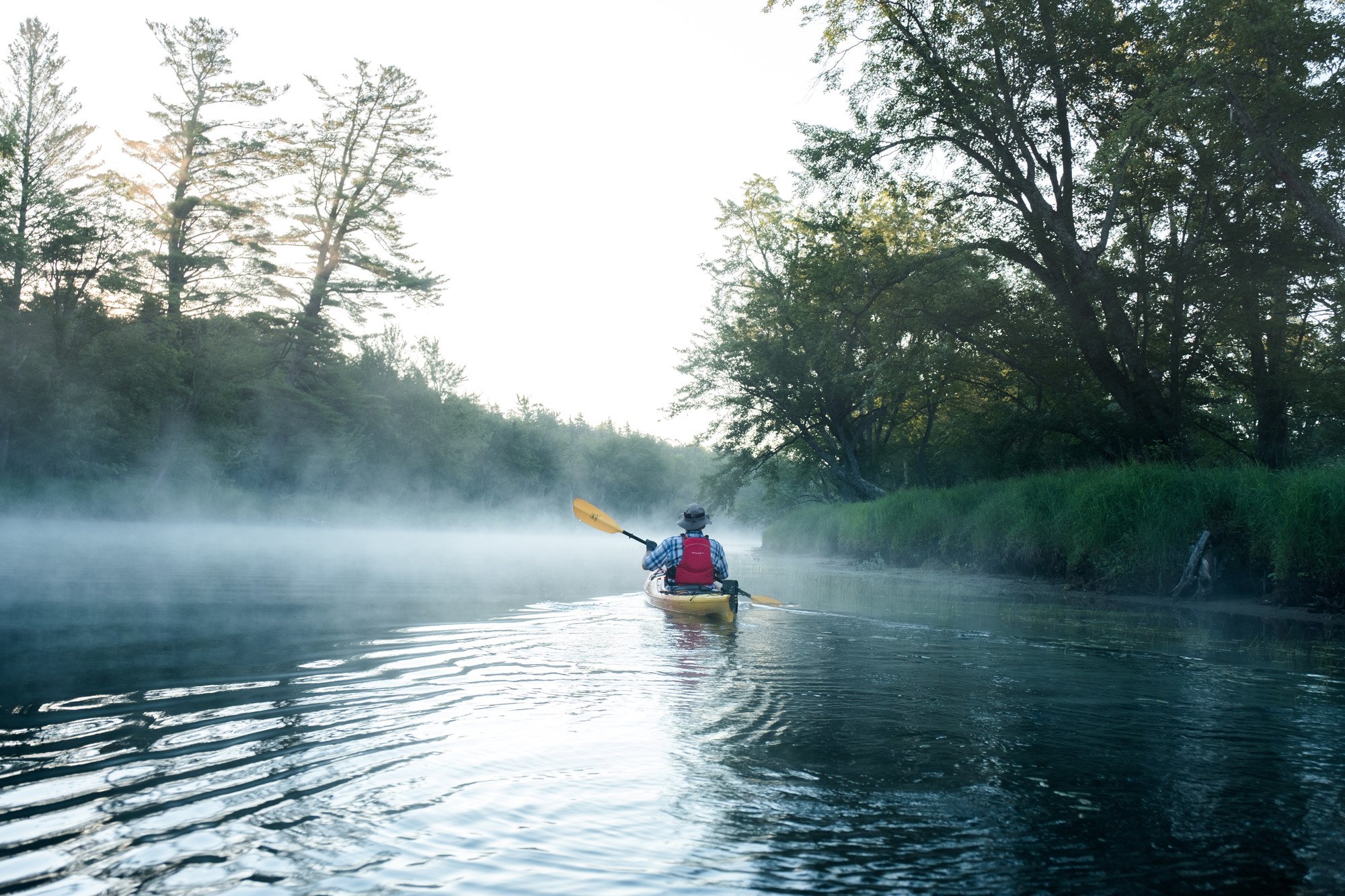 Kayaker paddling on Raquette River, part of the Northern Forest Canoe Trail
