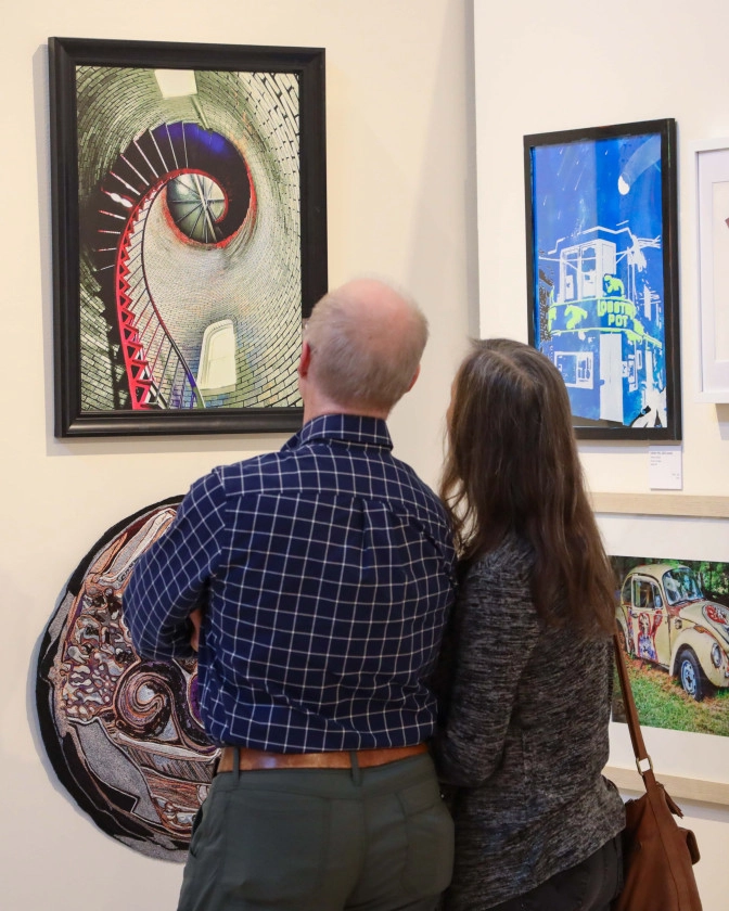 Man and woman admiring art works at the 75th Central Adirondacks Art Show in Old Forge.