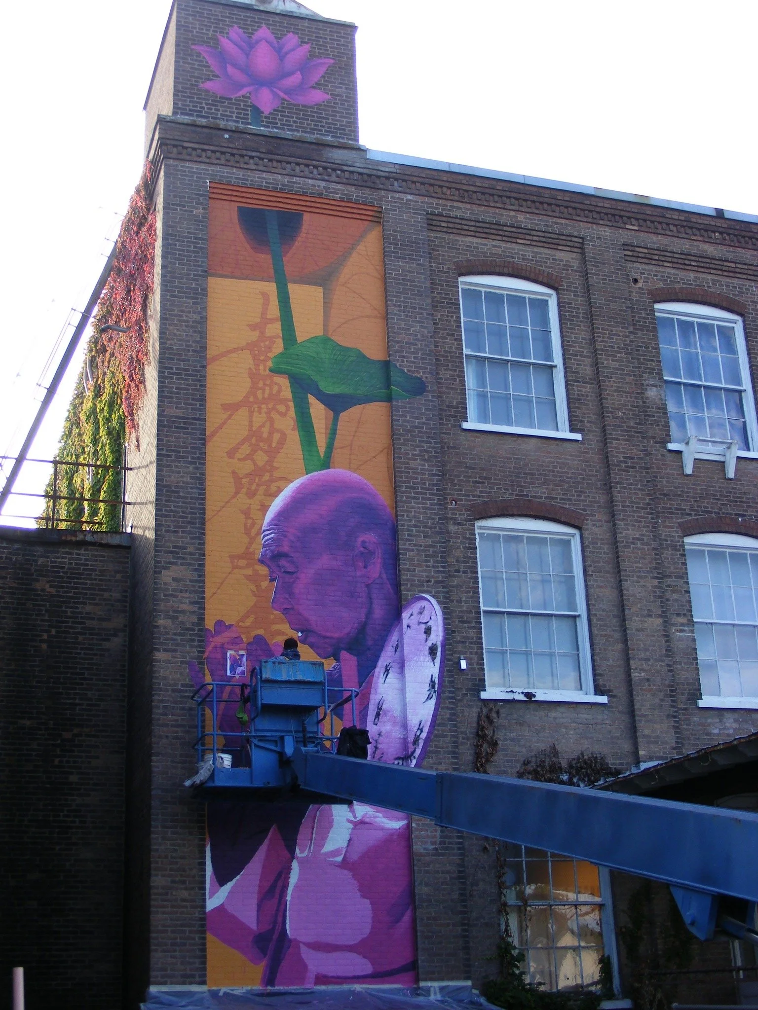 Mural being painted on the side of Glens Falls Shirt Factory creative space.