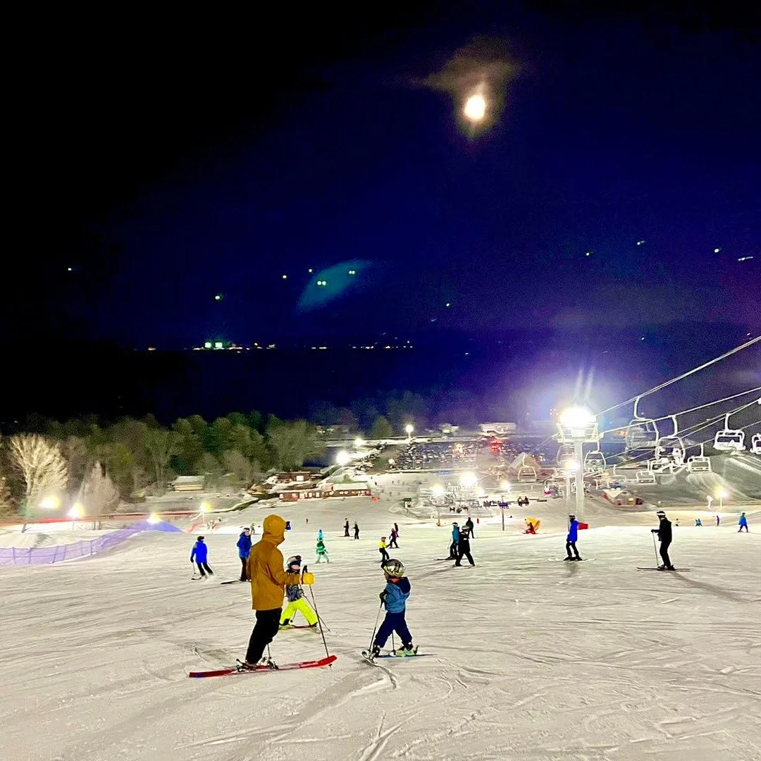 Family skiing at night at West Mountain in the Adirondacks.