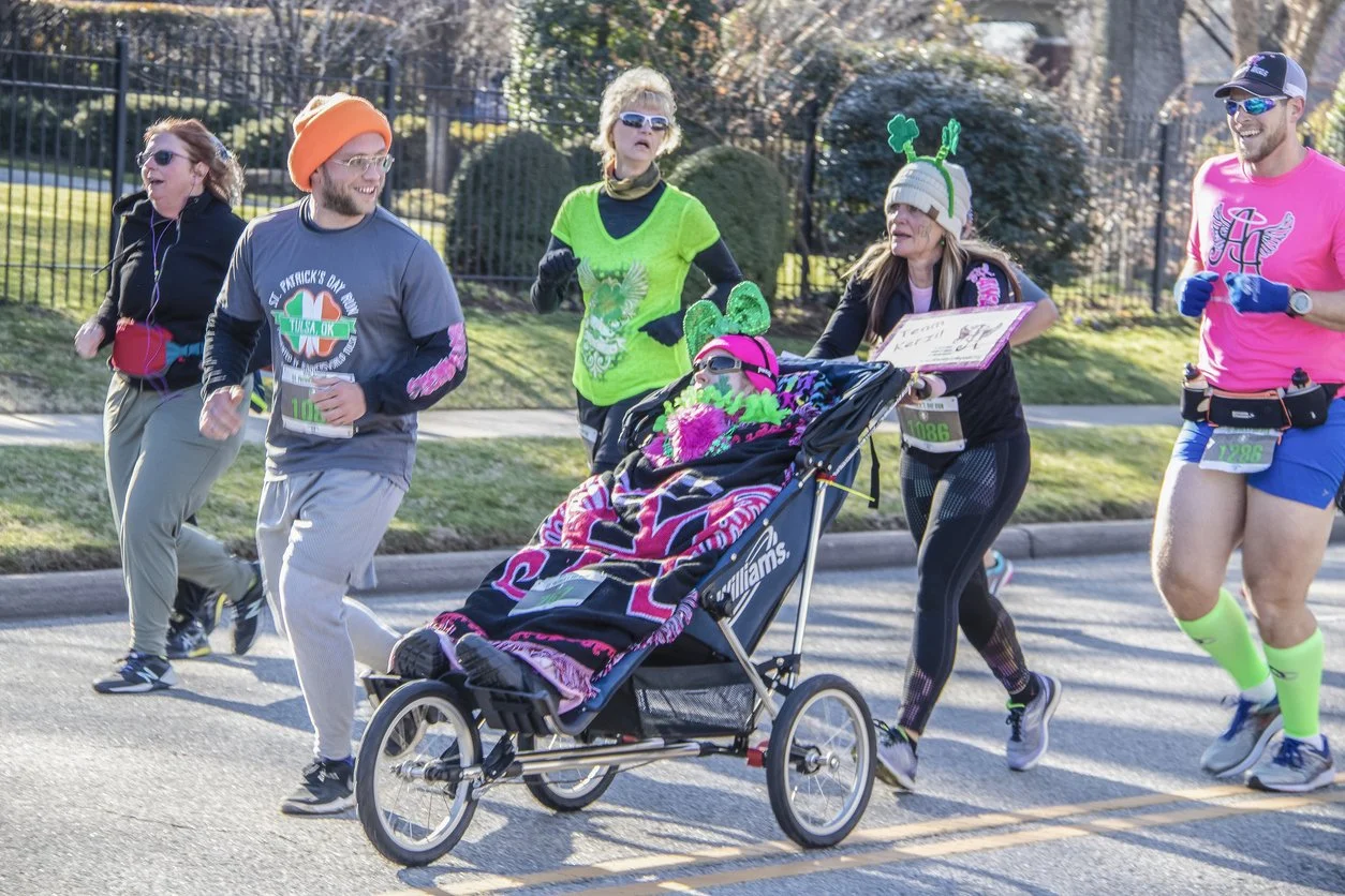 People running in a st patrick's day race with a disabled person.